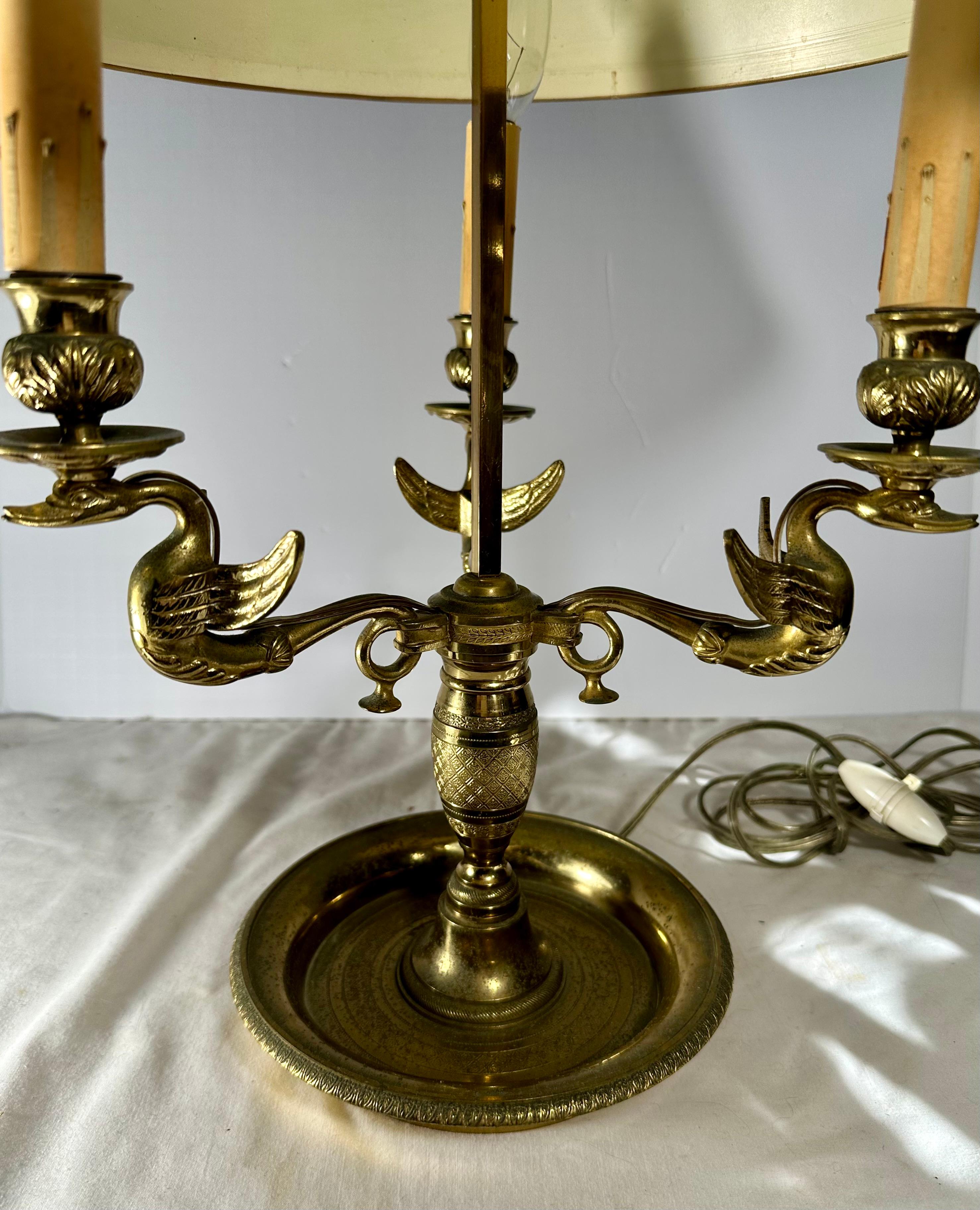Lampe de table à trois lumières du début du 19e siècle, de style Empire français, en tôle verte. 

Belle lampe Bouillotte Empire en laiton avec trois bras à enroulement décorés de cygnes. Une tige finement ciselée soutient les branches avec trois