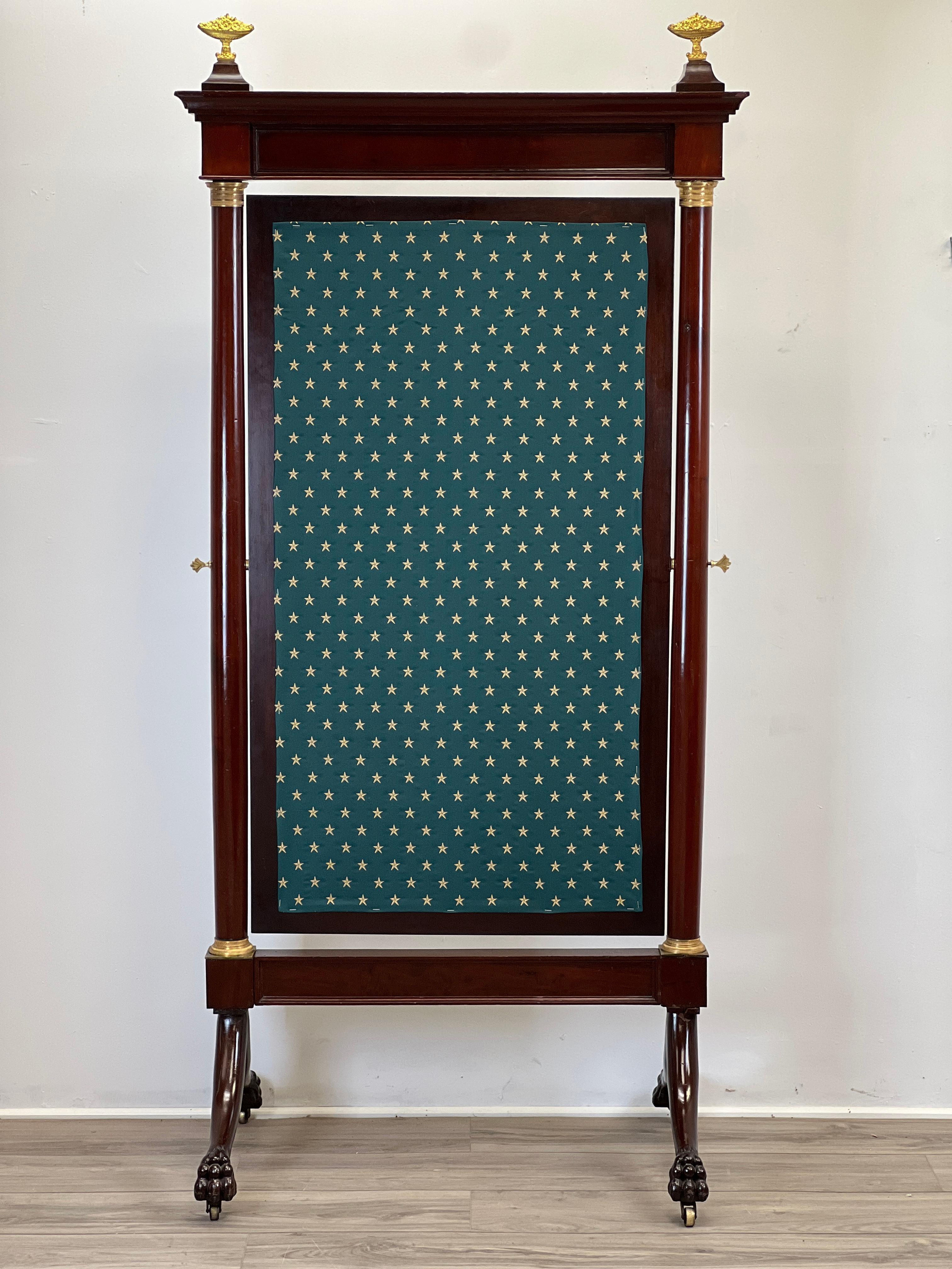 Featuring a very handsome period French Empire free standing Cheval mirror. The mirror frame and stand are made of solid mahogany. The frame consists of two turned columns mounted on top of sweeping legs terminating in lions paw feet. The top crest