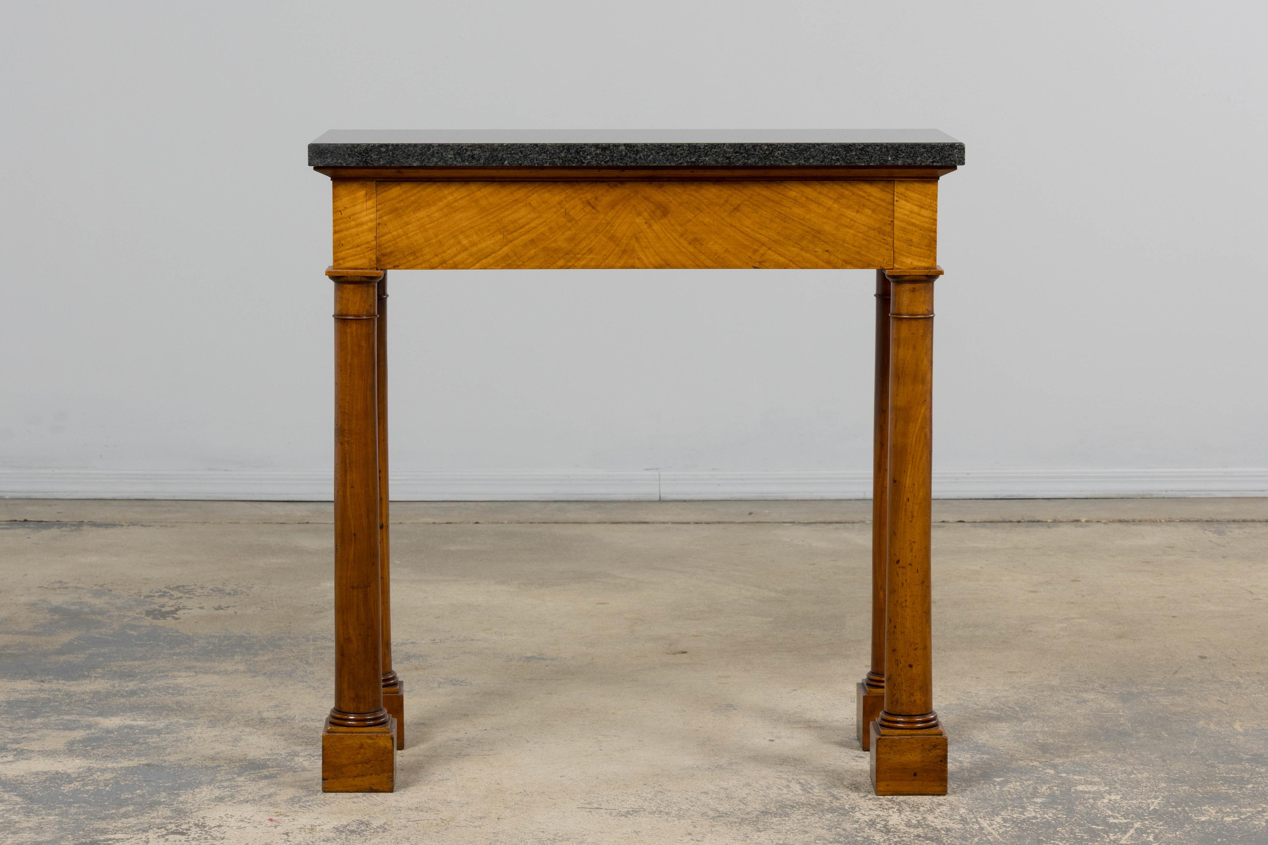 An early 19th century French Empire console table, sourced in Provence. The piece is constructed in solid mahogany with a rectangular dark grey granite top resting above a single apron drawer. The drawer front is veneered in figured mahogany,