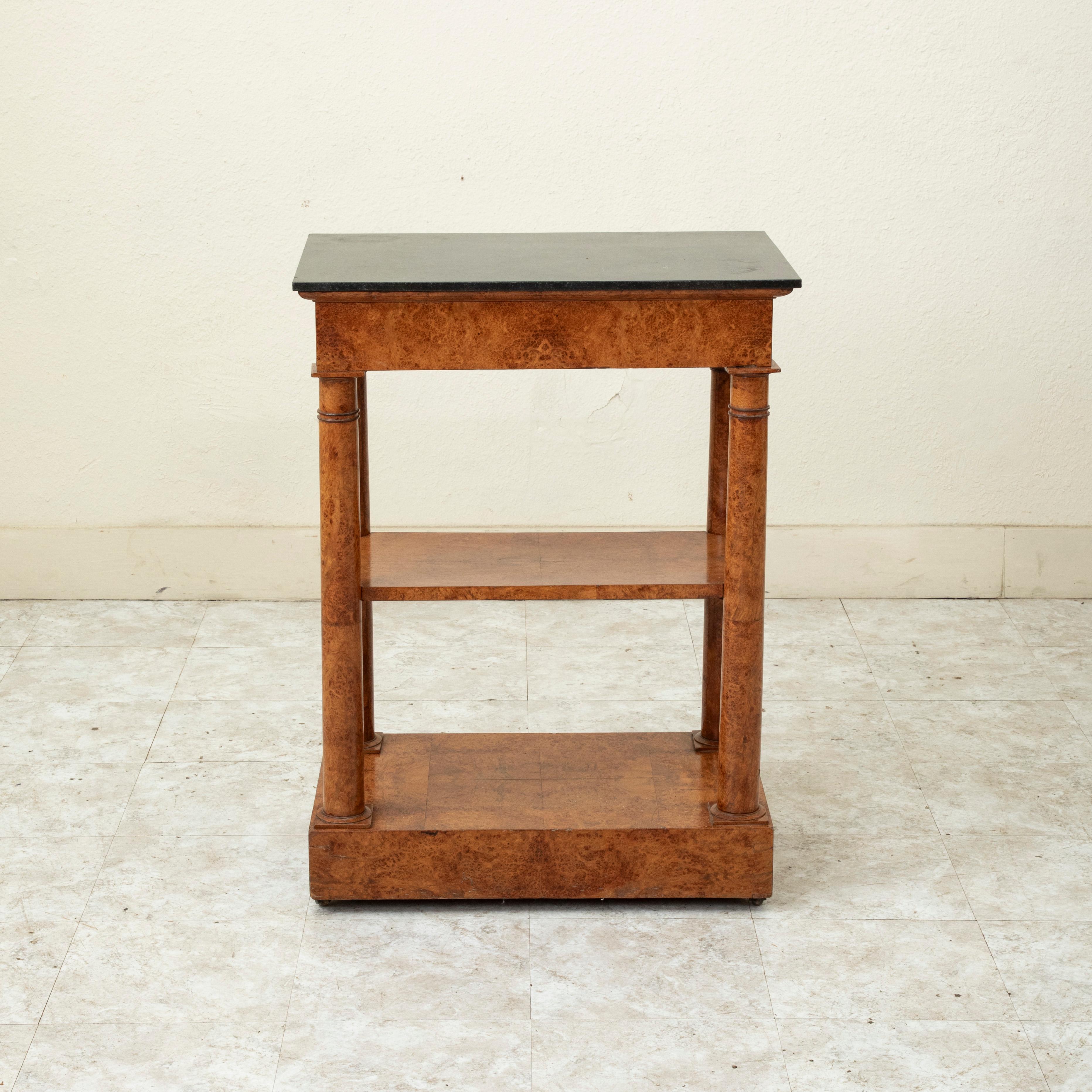 This small scale early nineteenth century French Empire period console table is constructed of solid burl elm and features a black marble top. A single drawer of dovetail construction fits seamlessly on one end into the apron below the marble top.