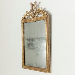 Specchio in legno dorato del periodo Impero francese dell'inizio del XIX secolo con lira e ghirlanda
