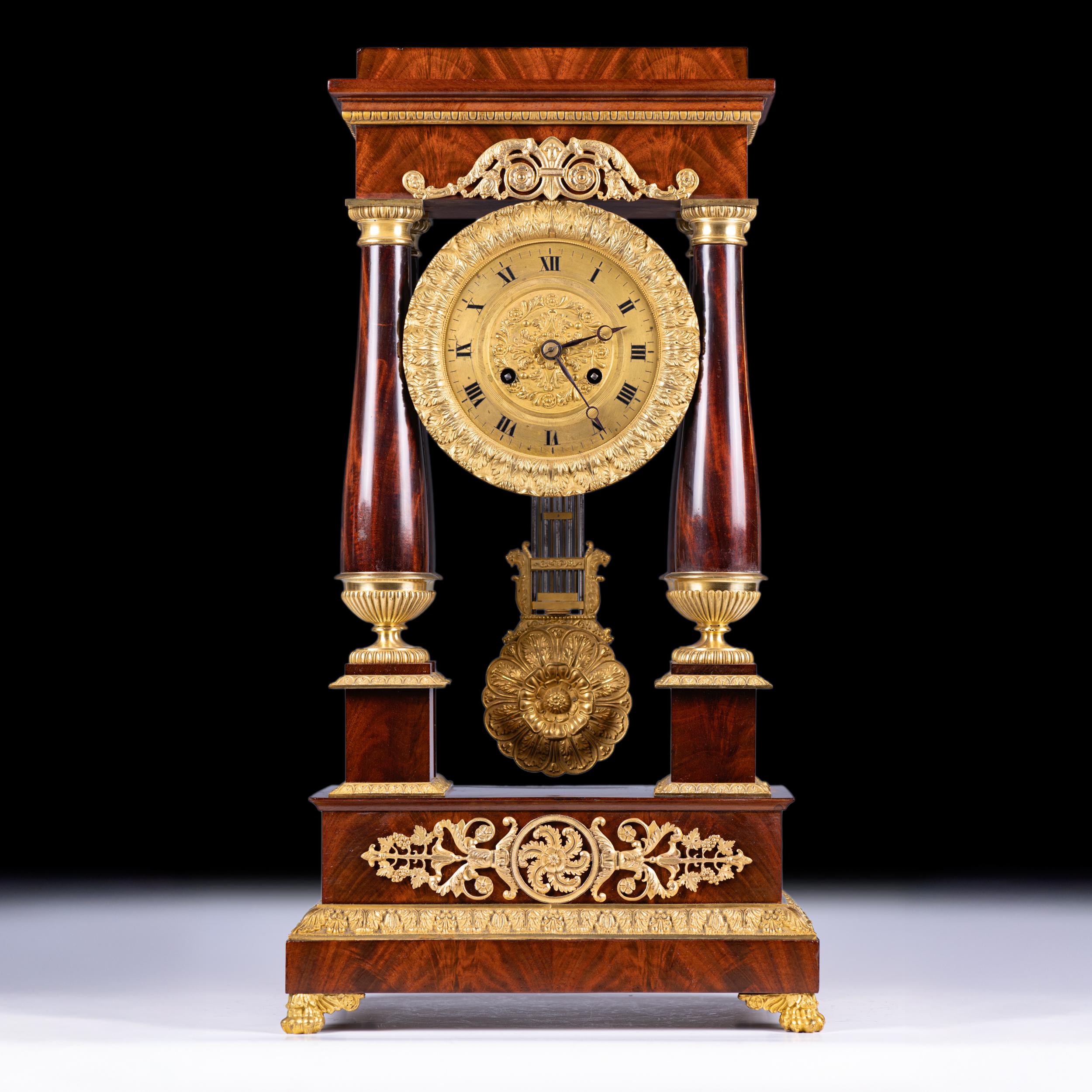 Une belle horloge à portique du début du 19e siècle, d'époque Empire français, d'une qualité exceptionnelle dans le style néoclassique. L'horloge est logée dans un boîtier en acajou richement figuré avec quatre colonnes effilées soutenant la section