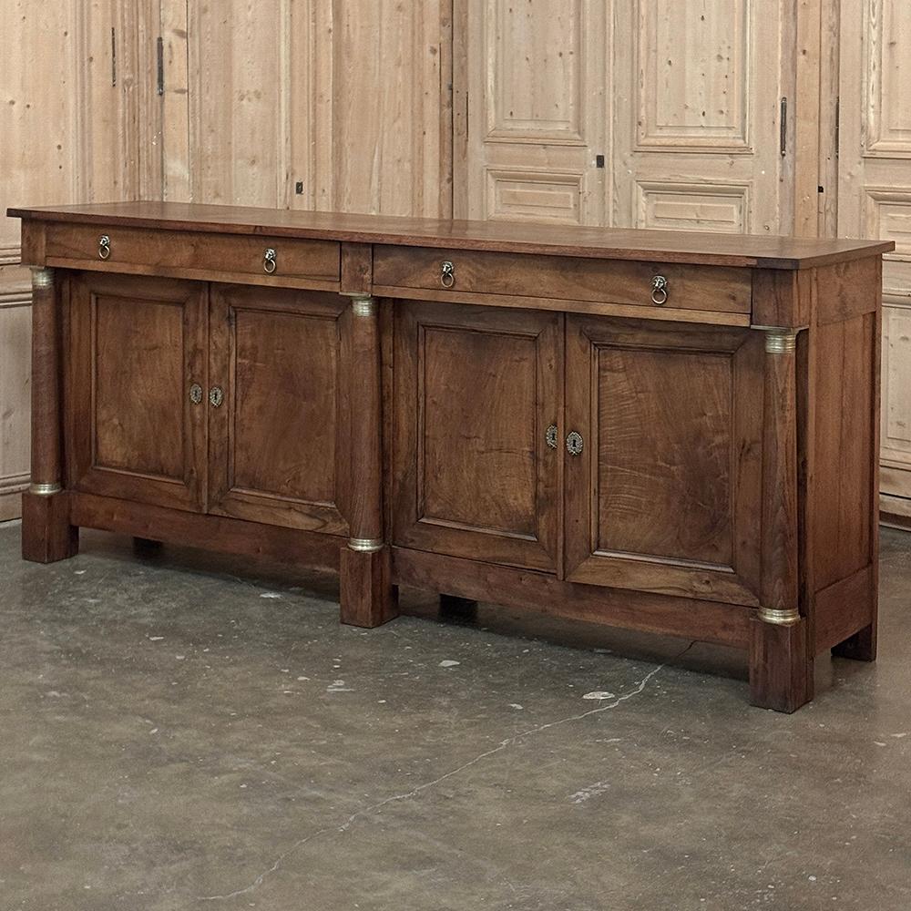 Early 19th Century French Empire Period Walnut Grand Buffet was meticulously hand-crafted by skilled artisans who drew inspiration from the royal families of their eras.  In this case, the piece was styled after the designs developed by Napoleon and