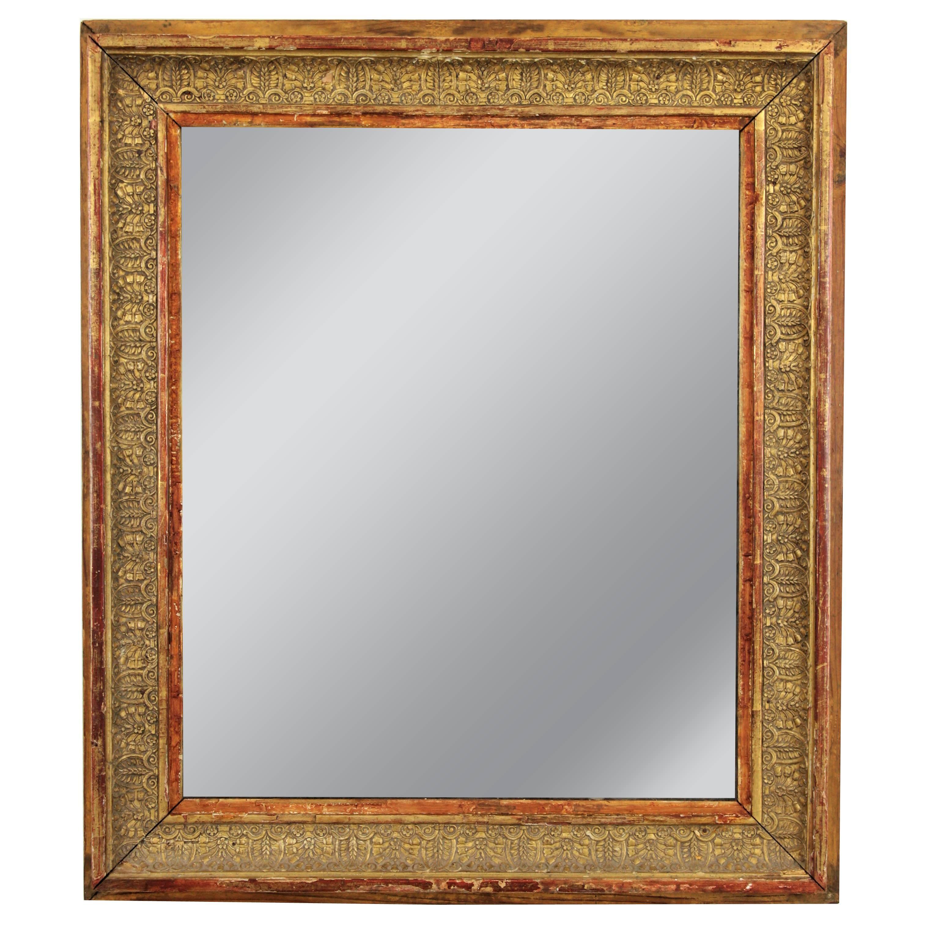 Antique French Empire giltwood mirror, France, 1815.
It has carved lead and floral details covered with gesso and gold leaf finish. The frame wears its original glass mirror showing a gorgeous wear and the wooden frame has a marvelous antique patina