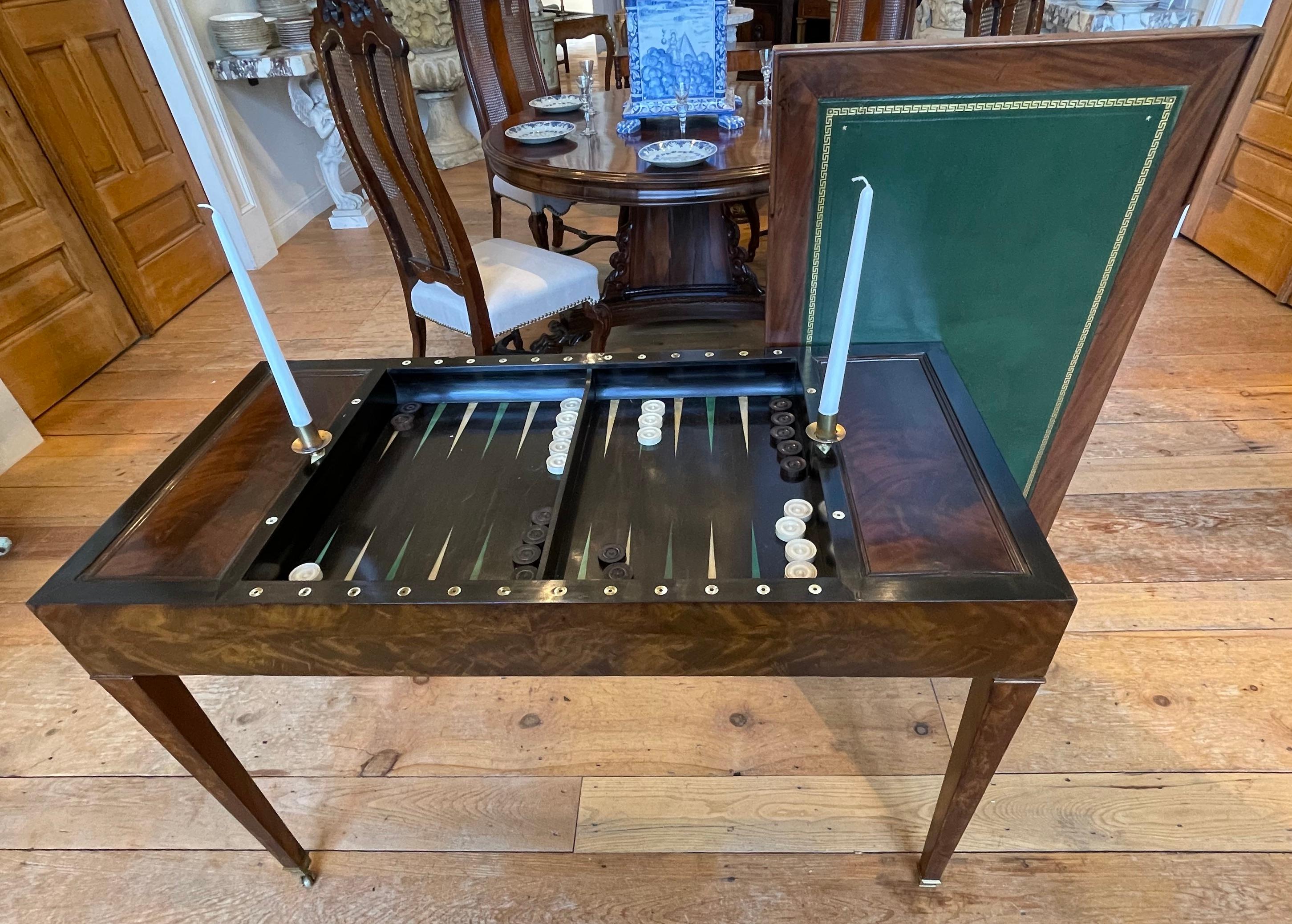 Period French Empire Mahogany Tric Trac Games Table.  Inlaid Backgammon Well.  Original Removable Top with leather on one side for writing and felt on reverse for card playing.  Original draught pieces.  Candleholders.

A beautiful piece 