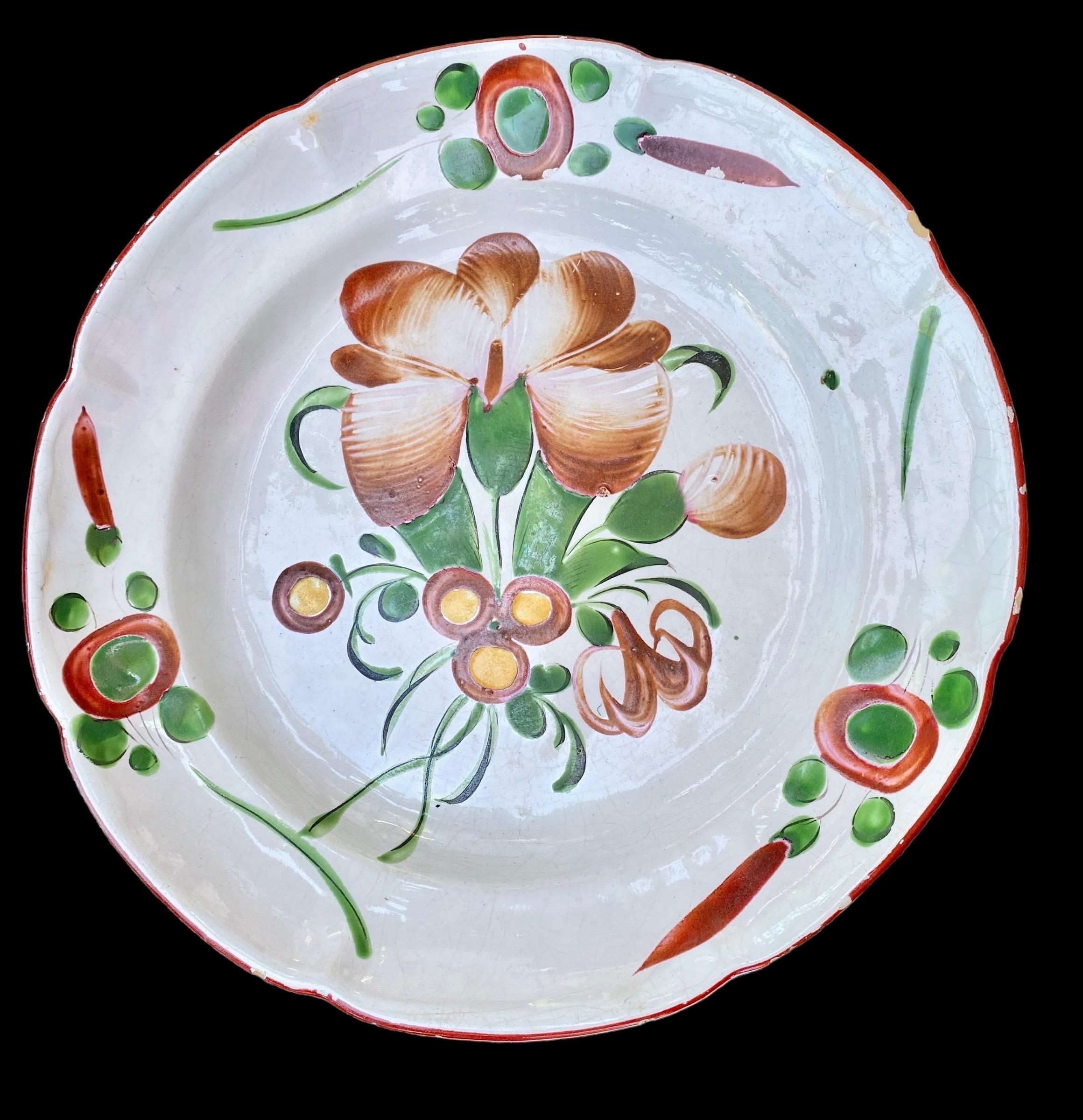 A 19th century French faience charger or platter with typical hand painted burgundy floral decoration from St Clement in the East of France. Minor glaze loss. Old brass plate hanger is still attached. 
