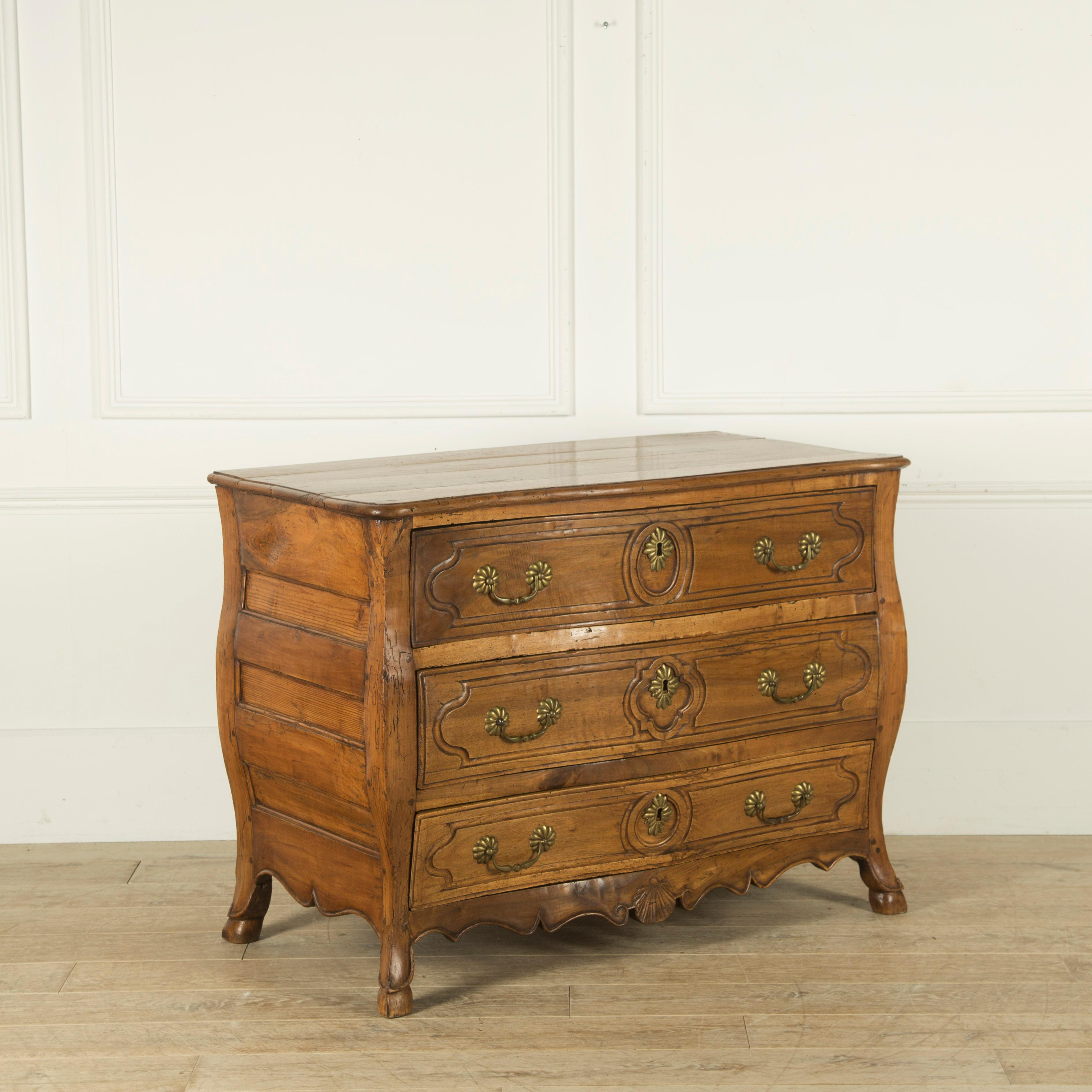 A French fruitwood three-drawer commode with bombe front and sides, circa 1820.