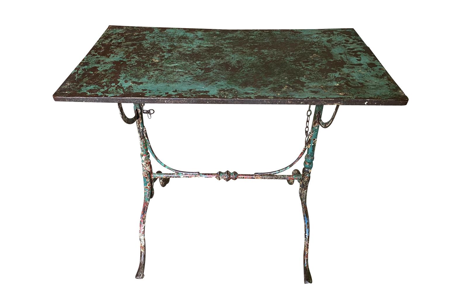 A wonderful and charming early 19th century Garden Table from the Provence region of France.  Soundly crafted from painted iron with a plateau that tilts and wonderfully sculpted legs, stretcher and feet.  Super patina and finish.  Perfect for any
