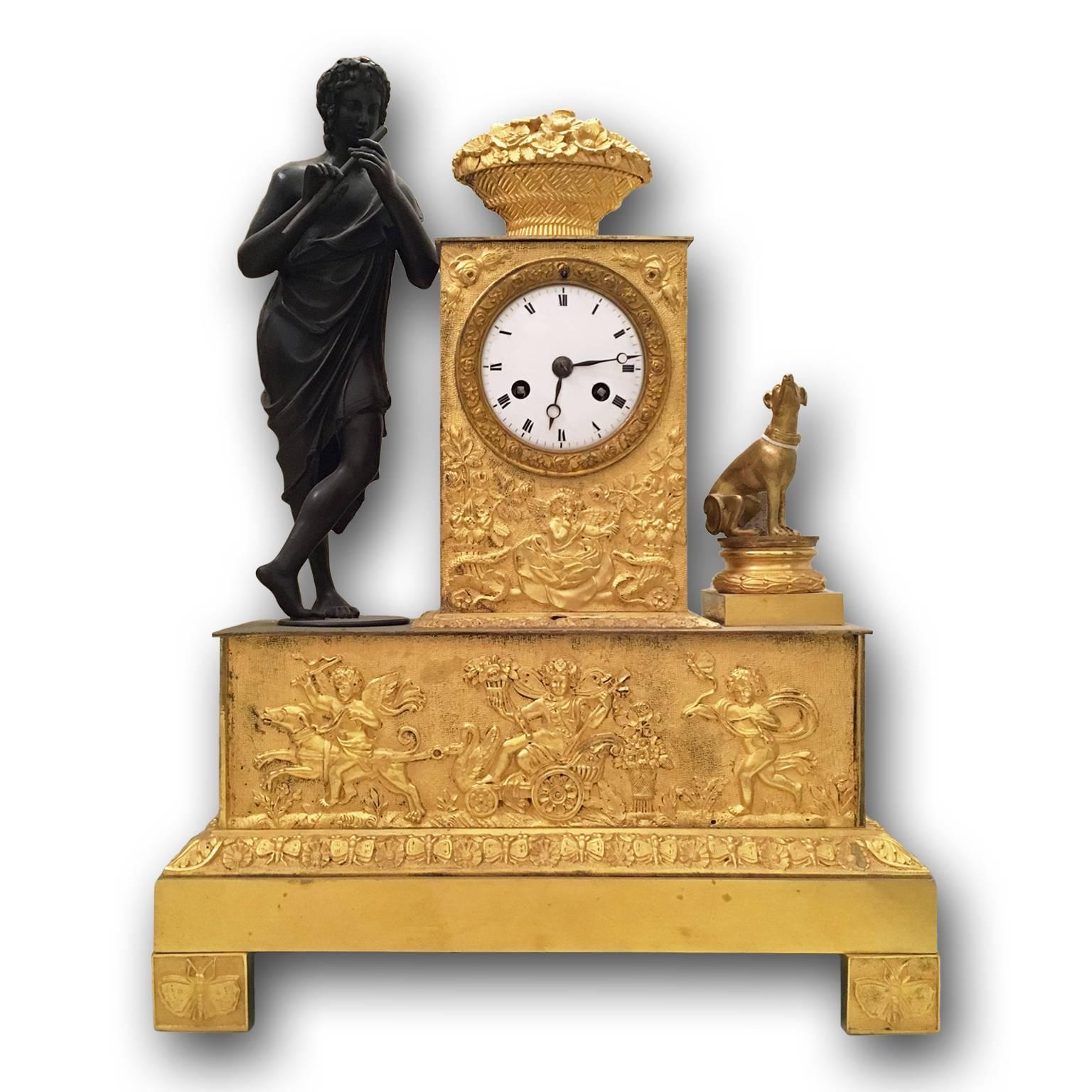 An amazing French neoclassical gilt bronze pendulum clock, retaining its original ormolu gilding, using the technique of lost-wax casting. The rectangular base and the clock case, which contains the dial with Roman numerals, are enriched by reliefs.