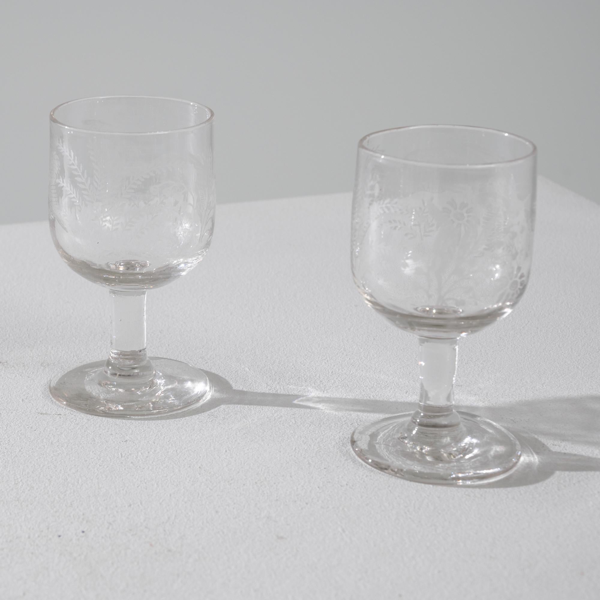 This set of early 19th century drinking glasses make an elegant addition to a table. The simple goblet shape, with its deep cup and wide base, serves equally well as a water or a wine glass — adaptable to any occasion. A delicate design of frosted