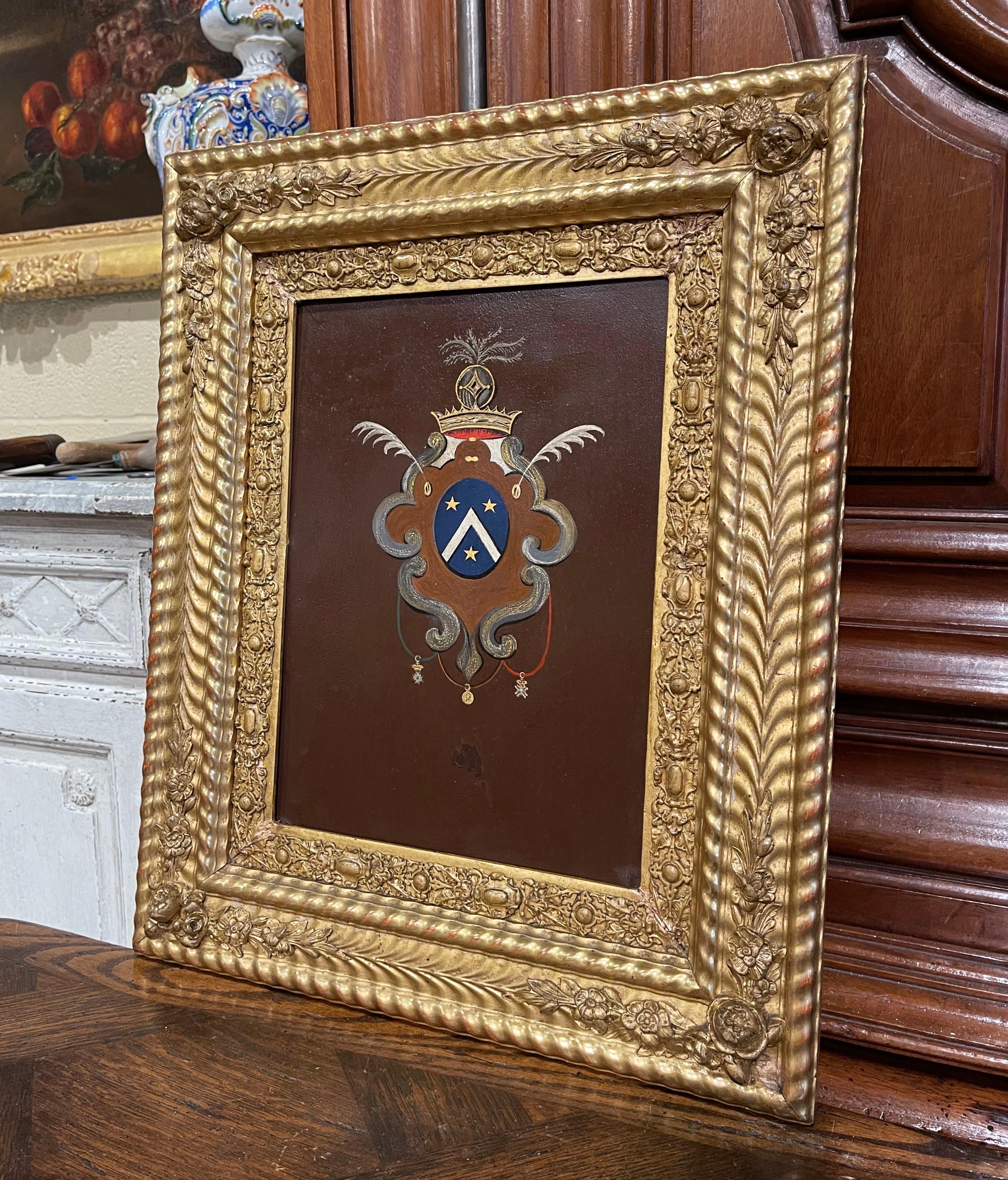 Decorate an office or study with this elegant antique wall decor. Crafted in France circa 1830, and set in the original carved gilt frame, the art work on metal features a hand painted family coat of arms embellished with a top crown, and