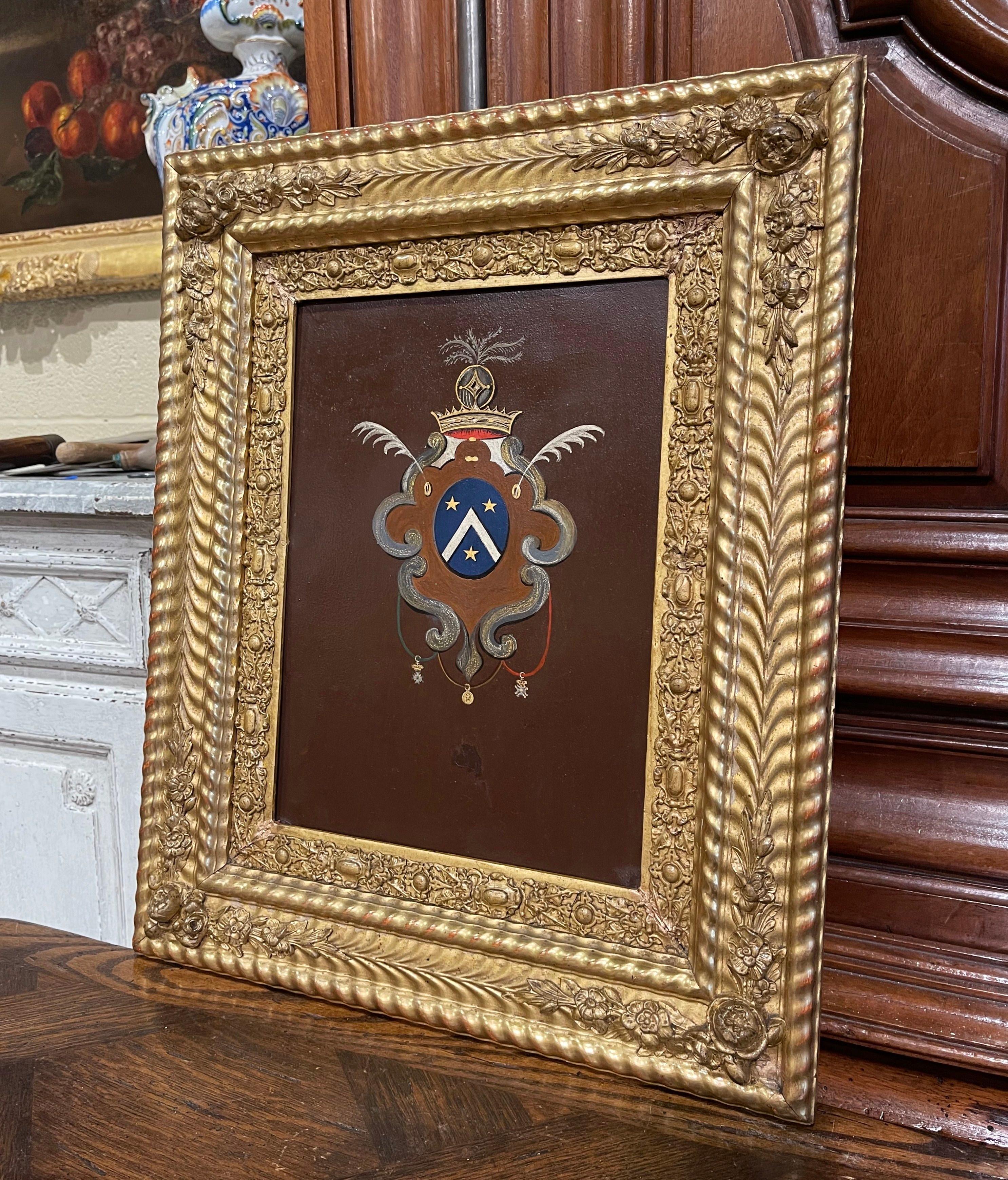 Décorez un bureau ou une étude avec cette élégante décoration murale ancienne. Fabriqué en France vers 1830, et placé dans son cadre doré sculpté d'origine, l'œuvre d'art sur métal présente un blason familial peint à la main, agrémenté d'une