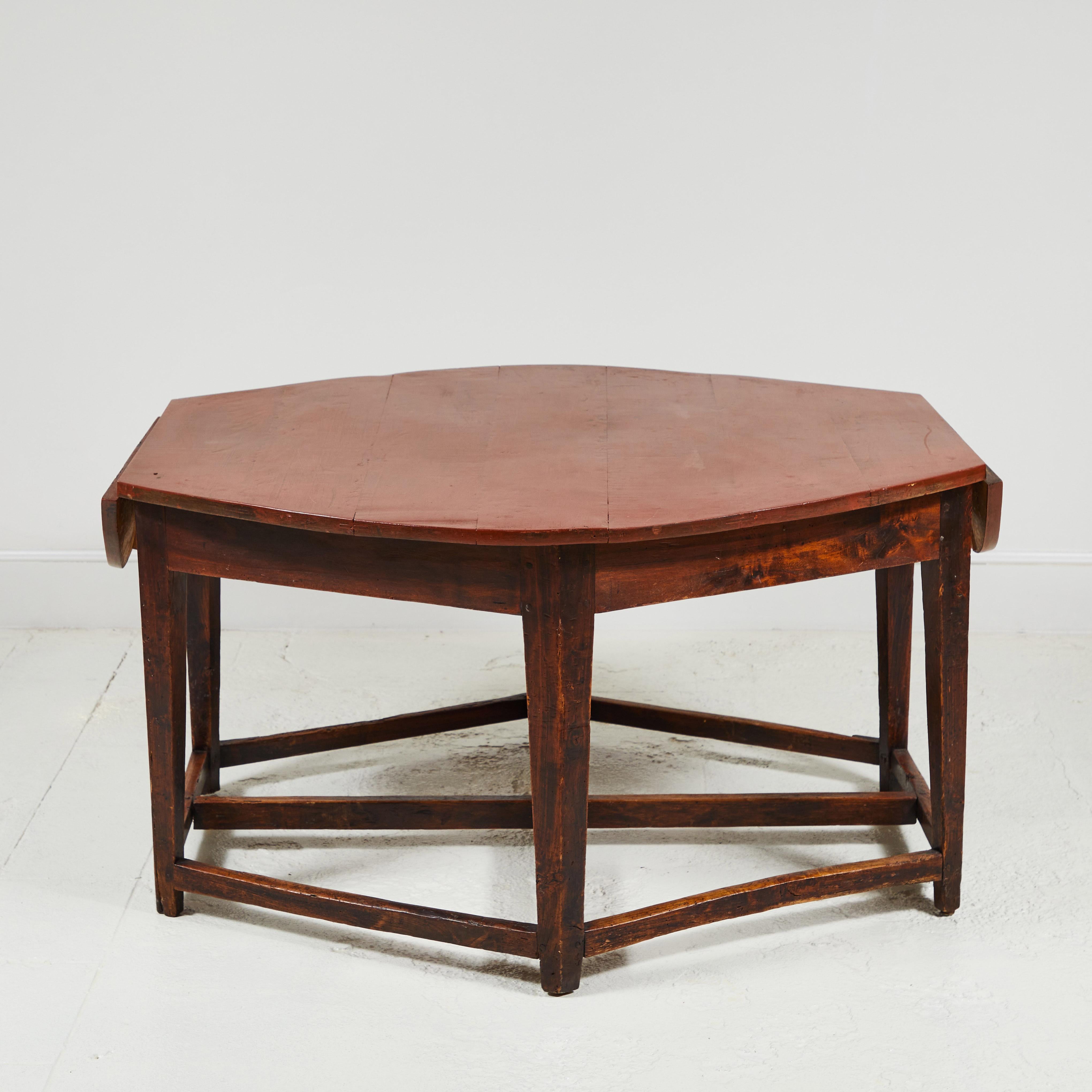 Rustic early 19th century French hexagonal table with two, drop leaves. Table offers two drawers, one of which is signed circa 1815. Cross base has beautiful aged markings.