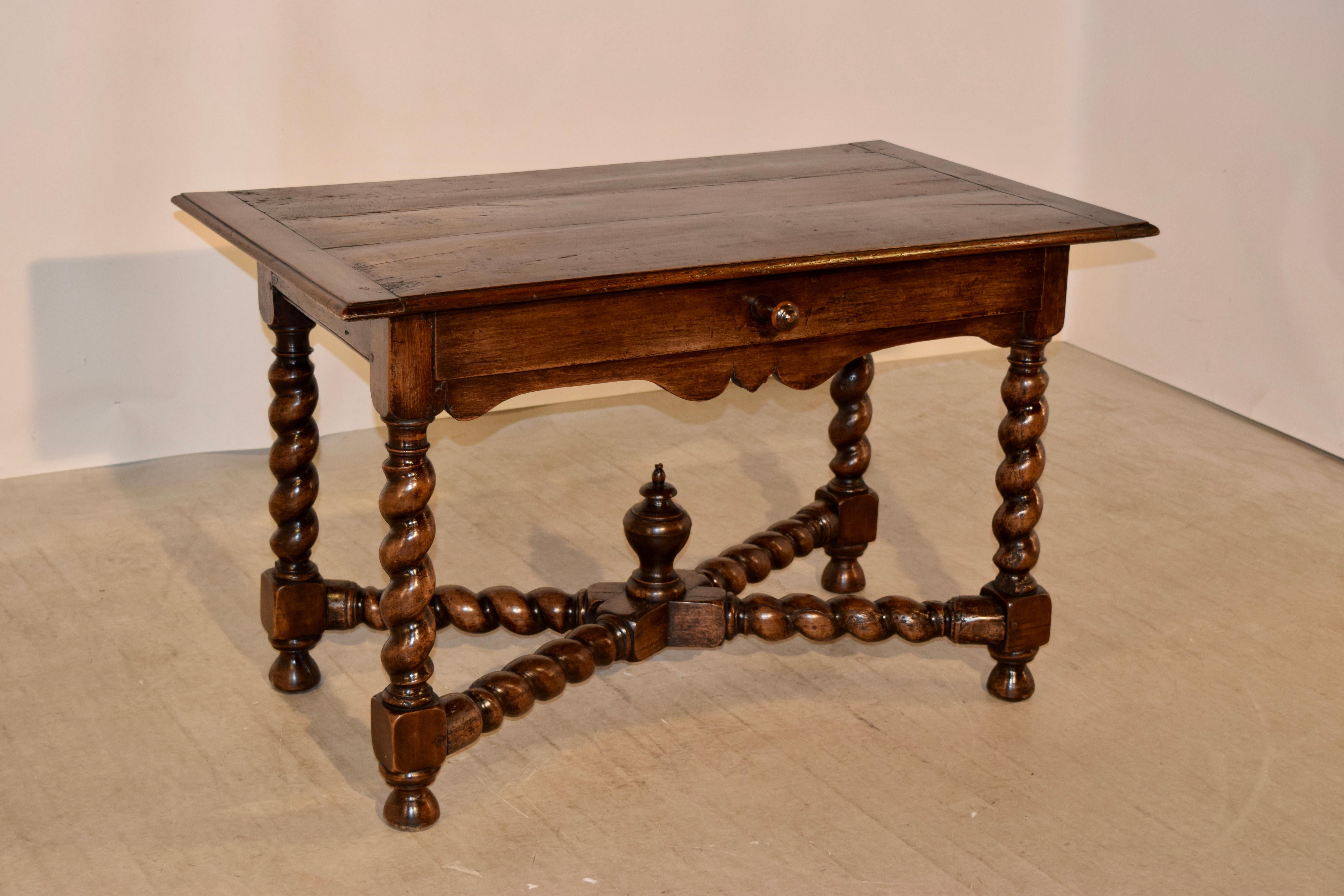 Early 19th century library table from France made from walnut. The top is banded on the ends, and has three planks, all with shrinkage from age and use. The top has a beveled edge as well. The apron contains a single drawer in the front, and has a