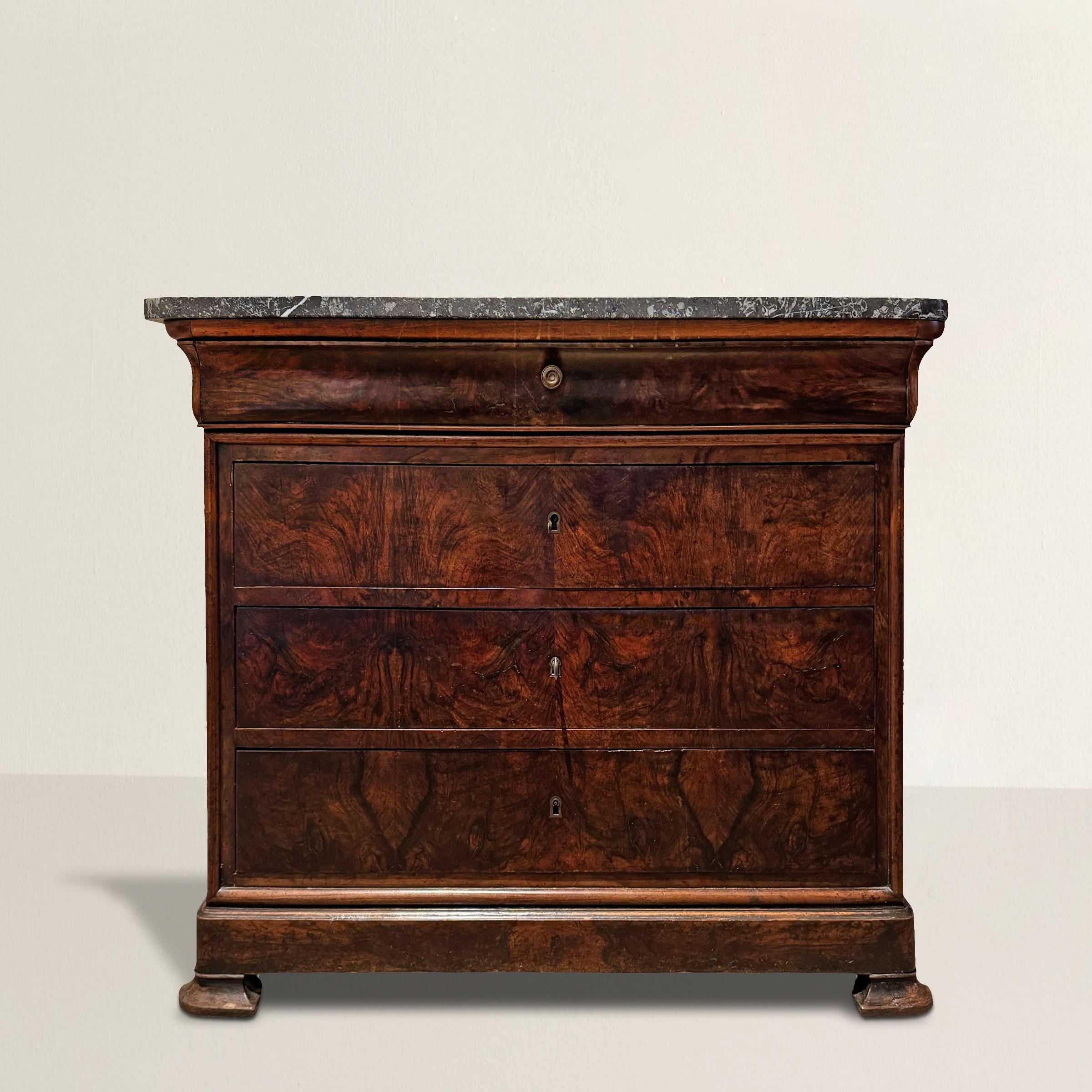Sleek, spare, and quietly stunning, this early 19th-century French Louis Philippe chest of drawers feels remarkably modern despite its age. Topped with its original thick slab of black marble—shot through with dramatic white quartz veining—it