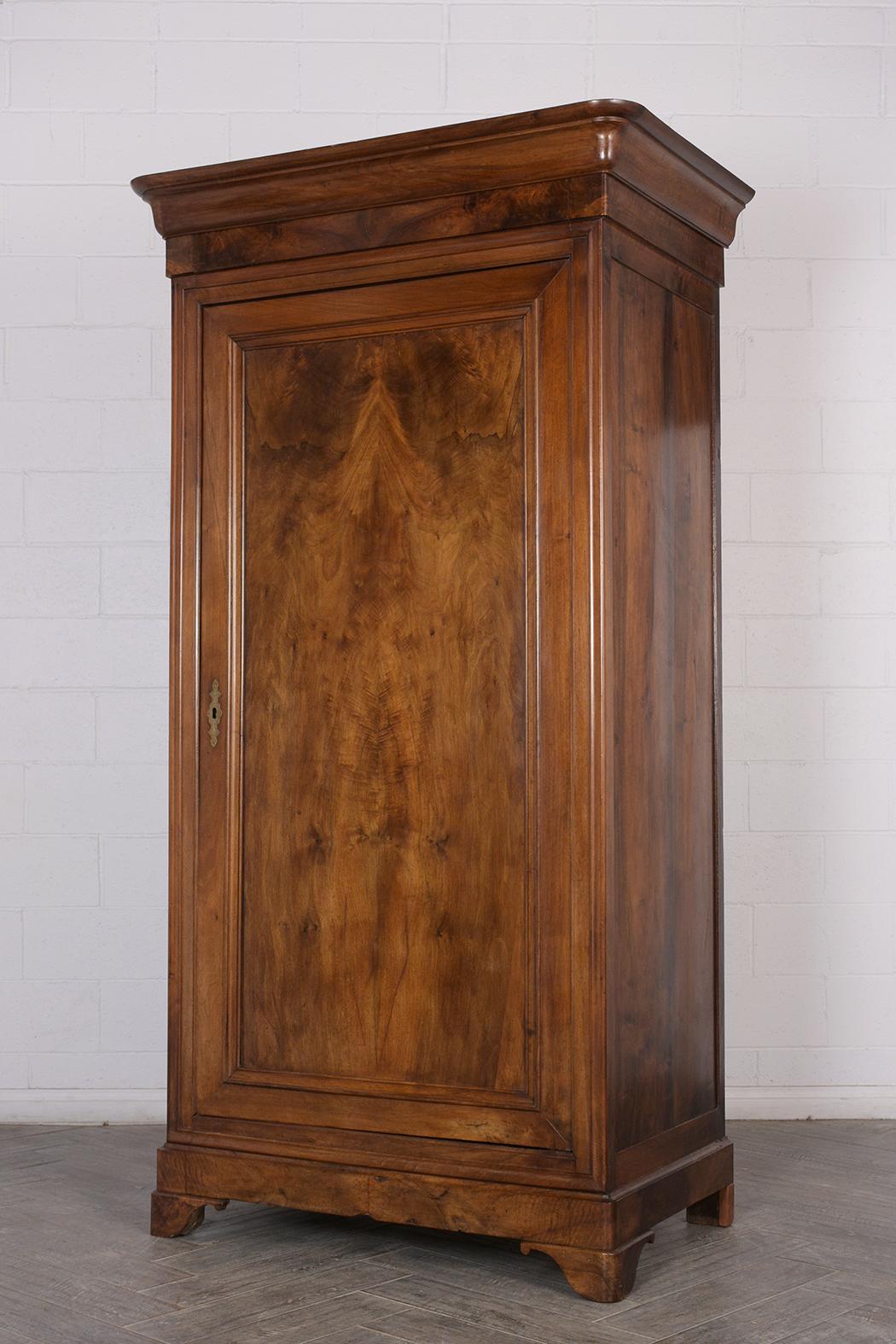 This Early 19th Century French Louis Philippe style Armoire has been completely restored and features the original color and French patina finish. The piece is made from solid walnut and features large molding on the top, single large door with a