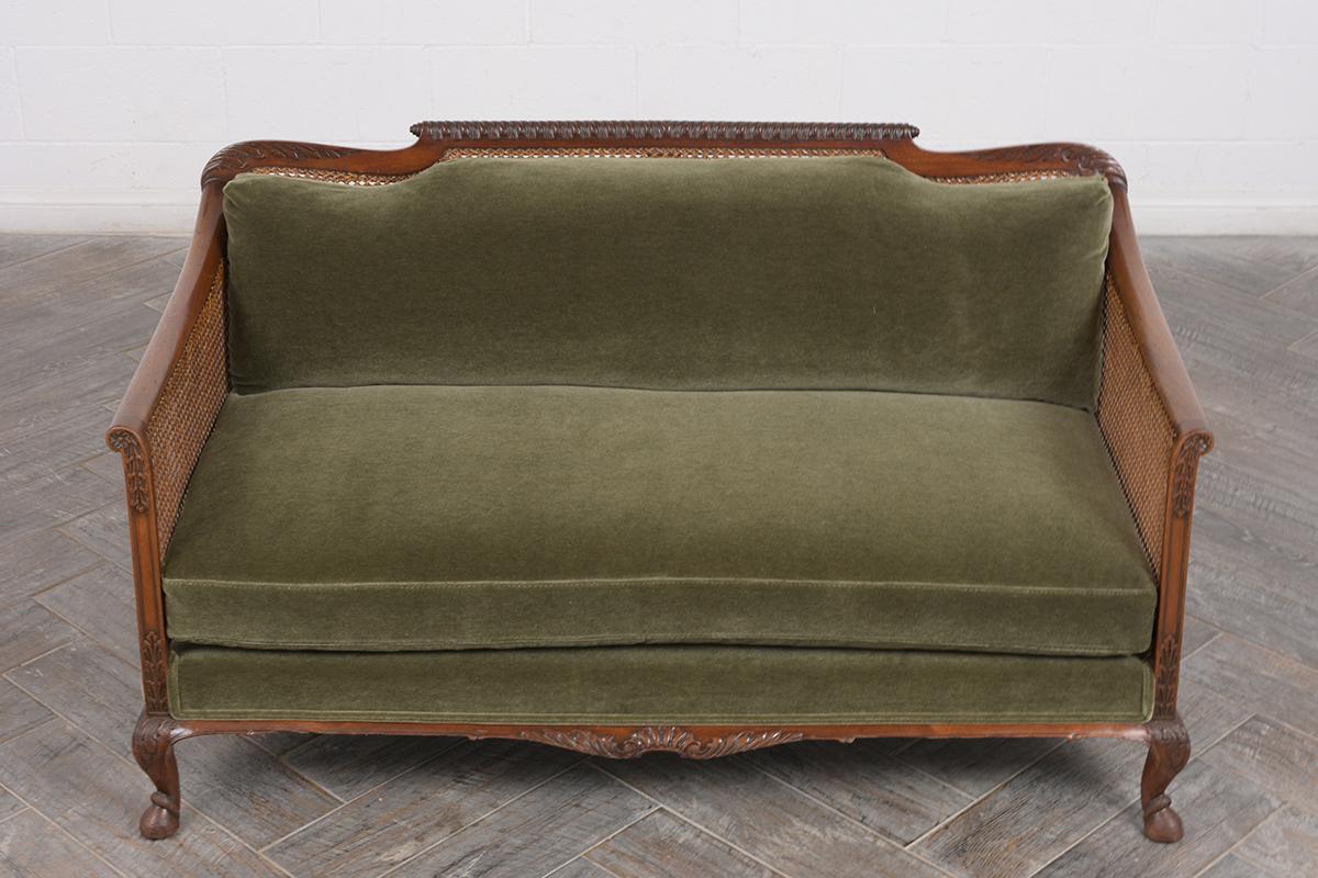 This 1850’s French Louis XIV Sofa has been recently restored, is made out of walnut, has hand-carved details throughout the frame, and features its It has the original caned backrest/sides in good condition. The back & seat cushion have top-stitch
