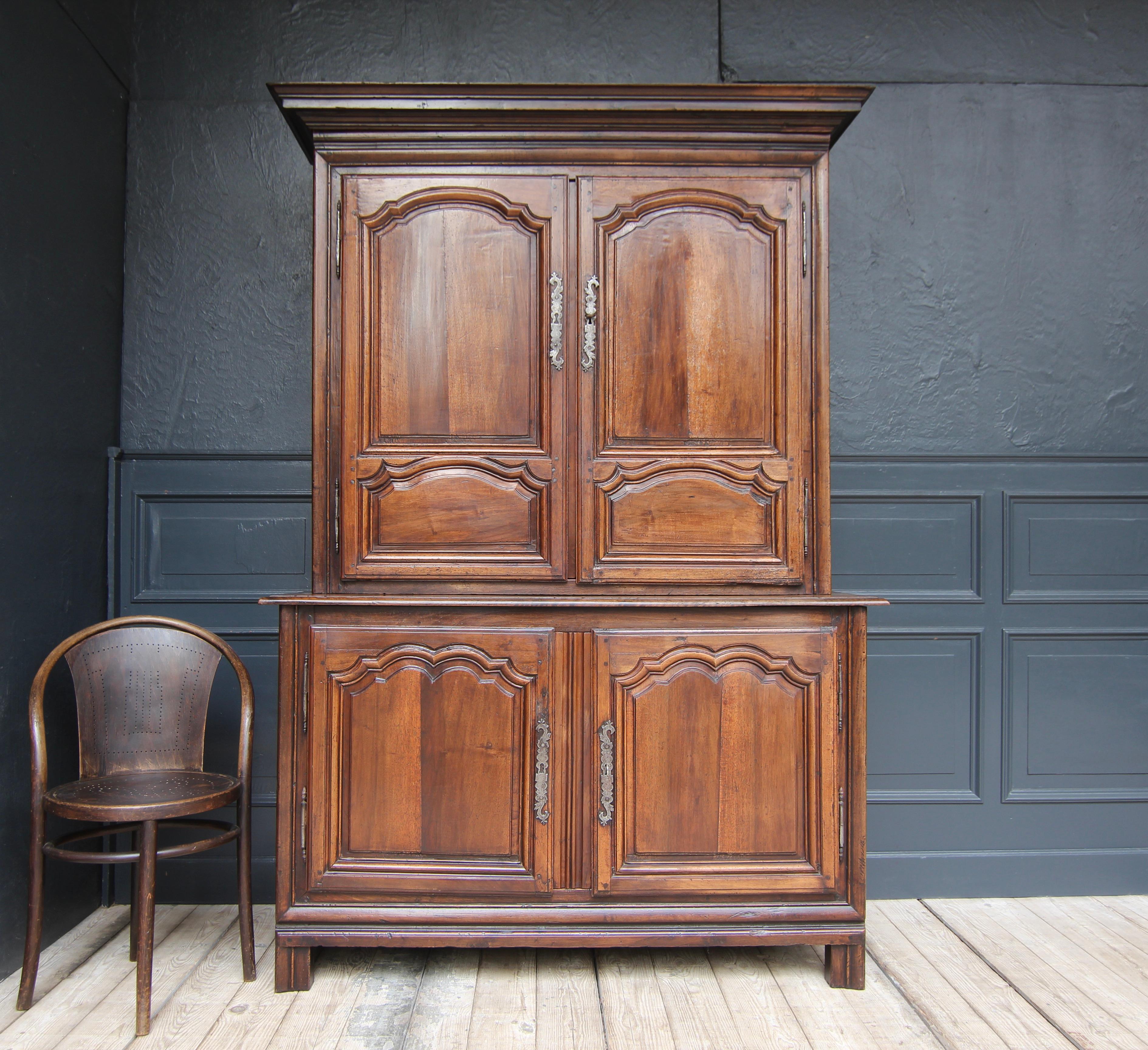 French buffet à deux corps or cabinet in Louis XIV style. Early 19th century. Made from solid walnut.

Two-part side-coffered walnut body consisting of a base cabinet with a slightly protruding profiled top panel and a slightly recessed upper