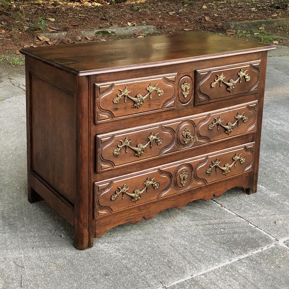 19th century French Walnut Louis XIV commode is a study in understated elegance! Finely contoured facade defines four spacious drawers that are very deep to make a truly functional piece. Exquisitely hand-cast bronze pulls and key guards hold a