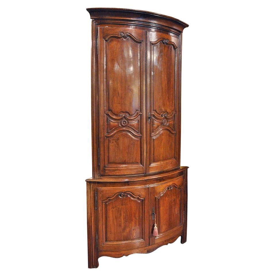 Armoire d'angle bombée Louis XV du début du XIXe siècle en noyer sculpté, deux pièces en vente