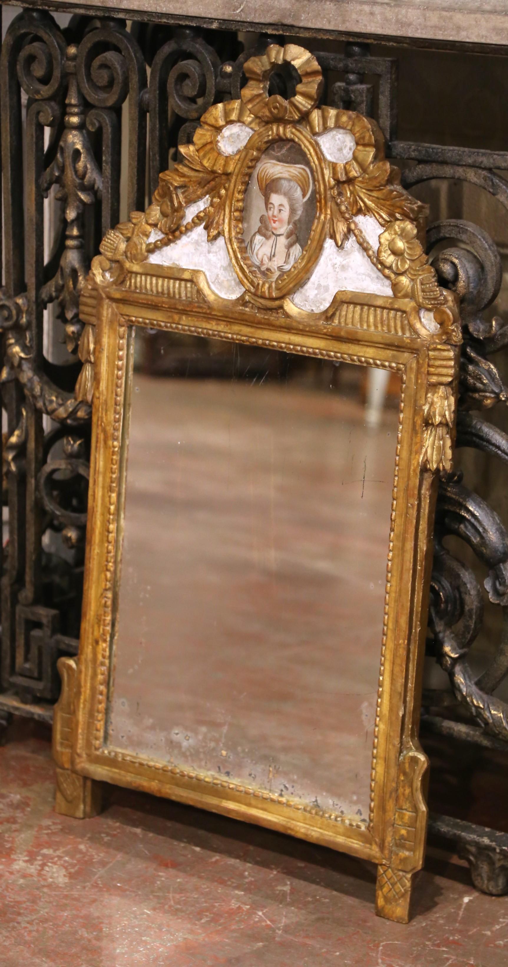 Ce miroir mural exquis a été fabriqué en France vers 1820 et illustre le style néoclassique raffiné associé à la période Louis XVI. Le cadre en bois doré est richement sculpté de motifs traditionnels, notamment des garnitures perlées, des guirlandes