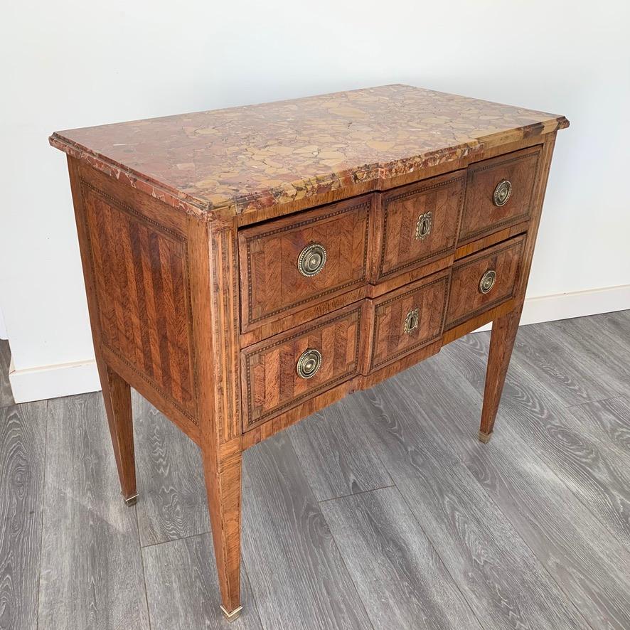 A lovely early 19th century French Louis XVI period 3/4 size two-drawer commode chest of drawers with its original breakfront marble top, matching the breakfront of the two drawer front, circa 1820.
Beautifully finished with the chevroned marquetry