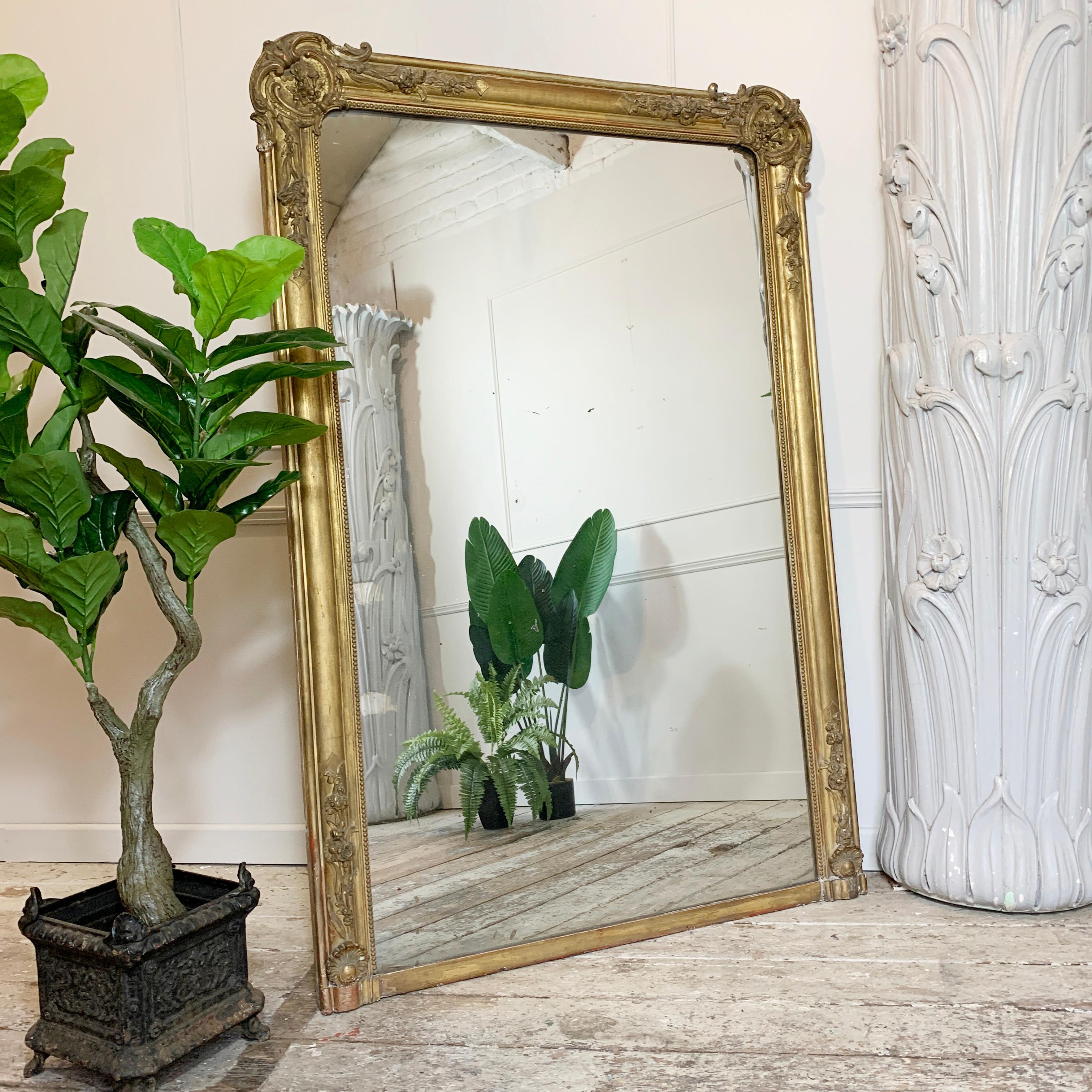 A quite extraordinary gilt French mirror, dating to the early 1800’s, the huge scale gilt gesso over wood frame, and thick mercury glass plate give this piece a fantastic look.

It is hard to see on the photos, but the foxing process on the