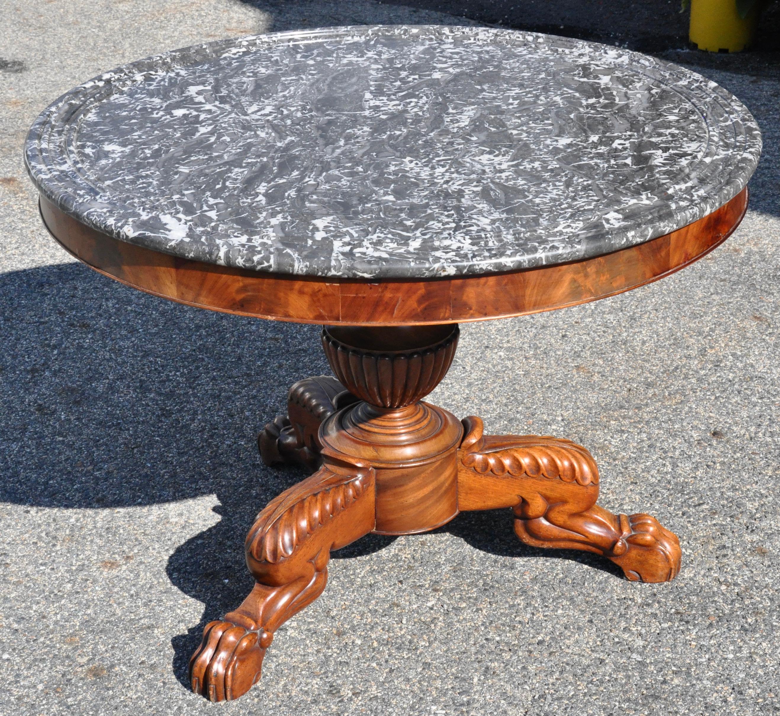Period early 19th century marble top mahogany center table. Baluster shaft with original marble top and paw lion legs.