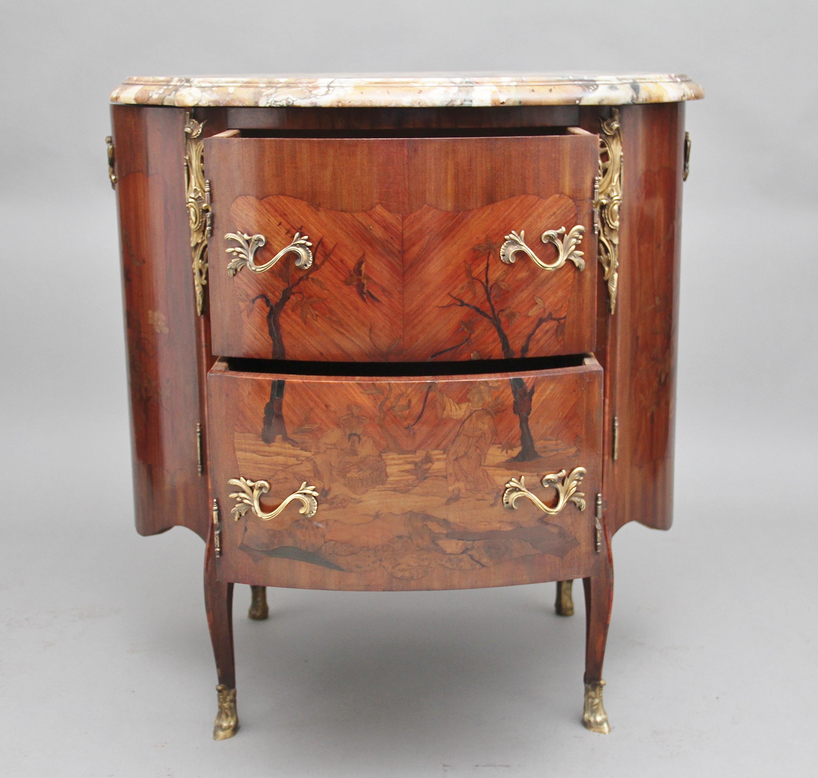 An unusual and rare early 19th century bow ended freestanding French marquetry marble top cabinet / stand made from tulip wood and inlaid with exotic woods, having the original white and grey moulded edge and shaped marble top, lovely marquetry