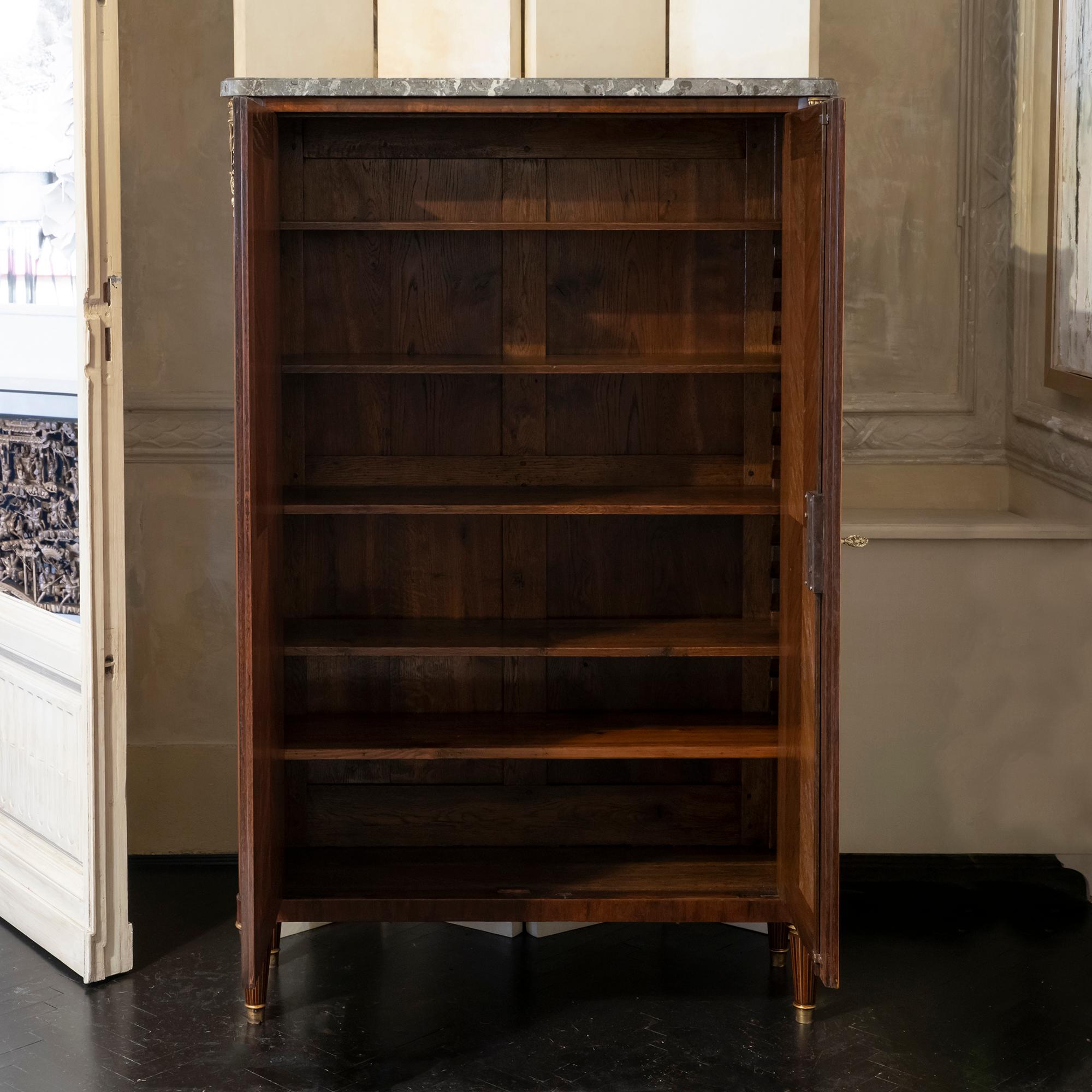 Early 19th century French tall cabinet / library geometric, contrasting-woods inlaid marquetry on the front doors and sides with decorative brass details over the fluted columns, original marble top with vintage patina and in good condition, five