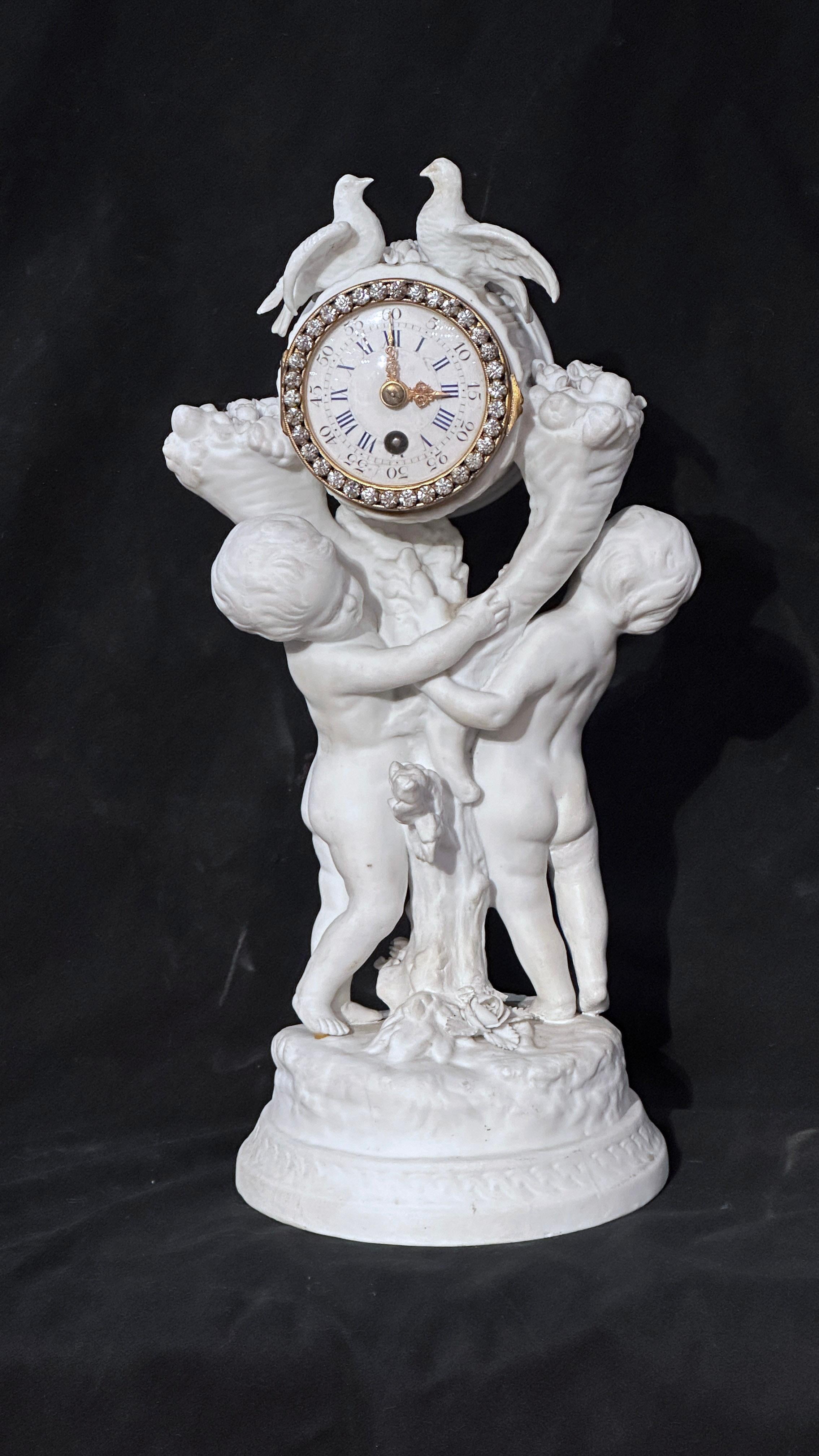 Elegante Biskuituhr mit einer Allegorie der reinen Liebe. Die federbelastete Uhr verfügt über ein emailliertes Zifferblatt mit doppelten arabischen und römischen Ziffern und eine Krone, die mit Zirkonen in Form von Diamanten besetzt ist. Das