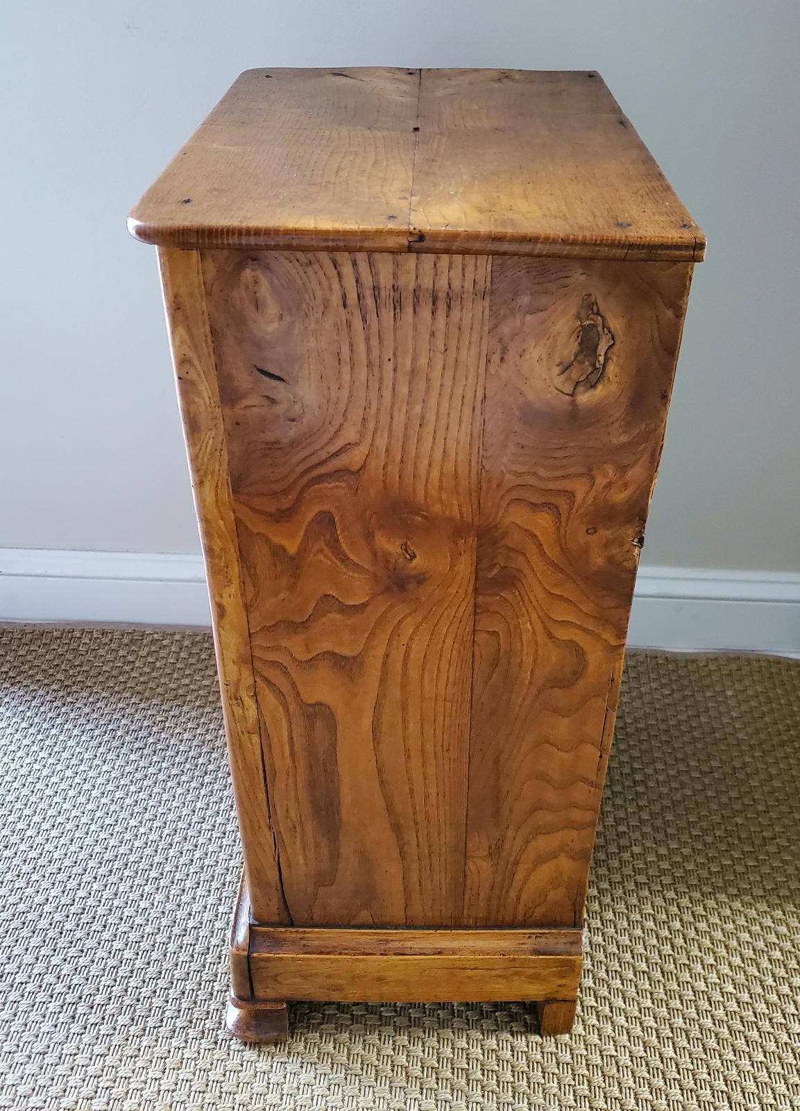 Early 19th Century French Provincial nightstand. Made of “Book Matched” burled ash with a deep color and original patination. Single drawer and cupboard. Loire Valley, circa 1820. Measures: 29.5” H 16” W 11.5” D.
 