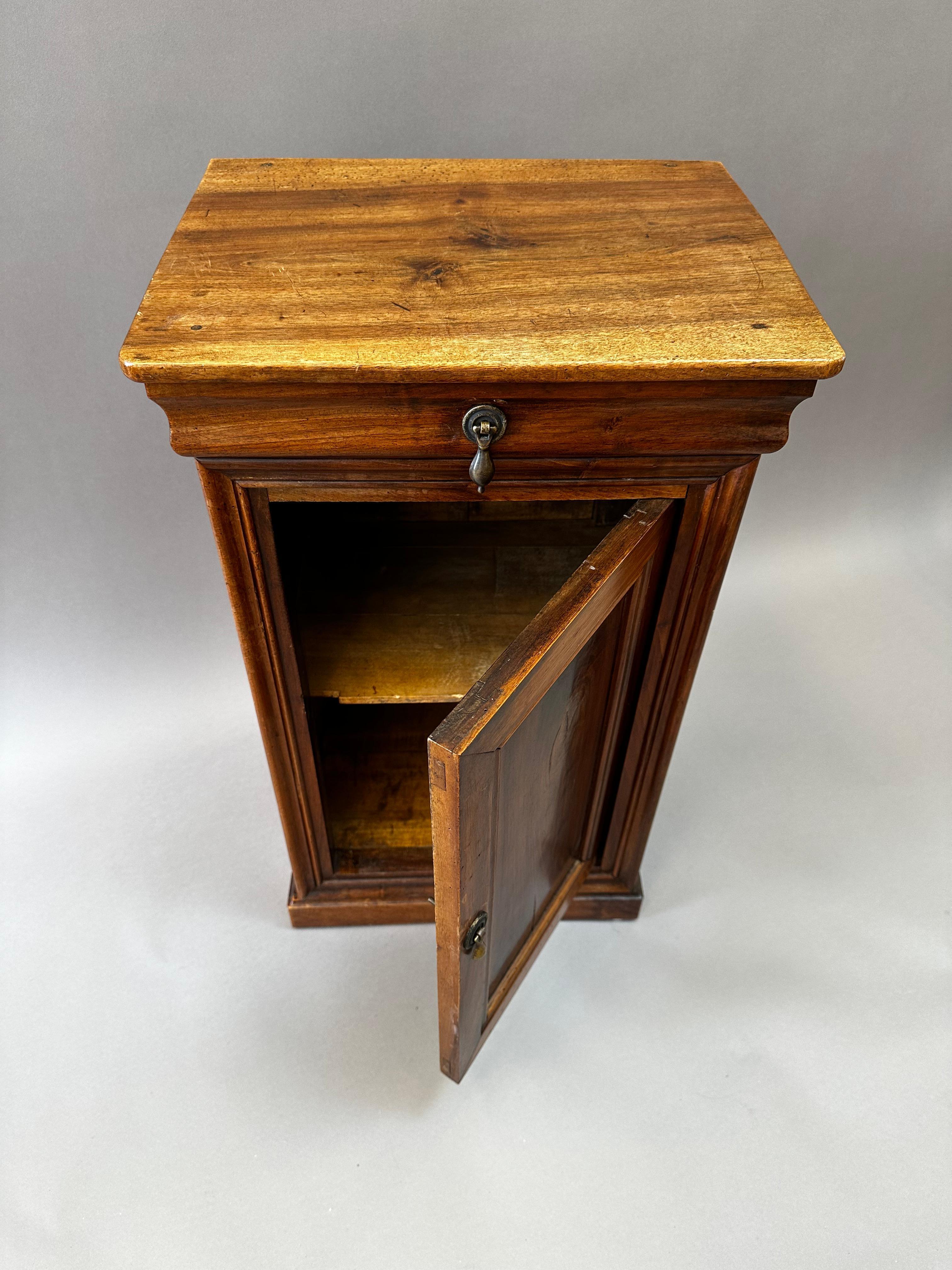 A charming French Provincial nightstand crafted in the early 19th century in the Loire Valley, circa 1820. This petite cabinet is made of richly figured Circassian walnut, known for its expressive grain and deep, lustrous color. The piece retains