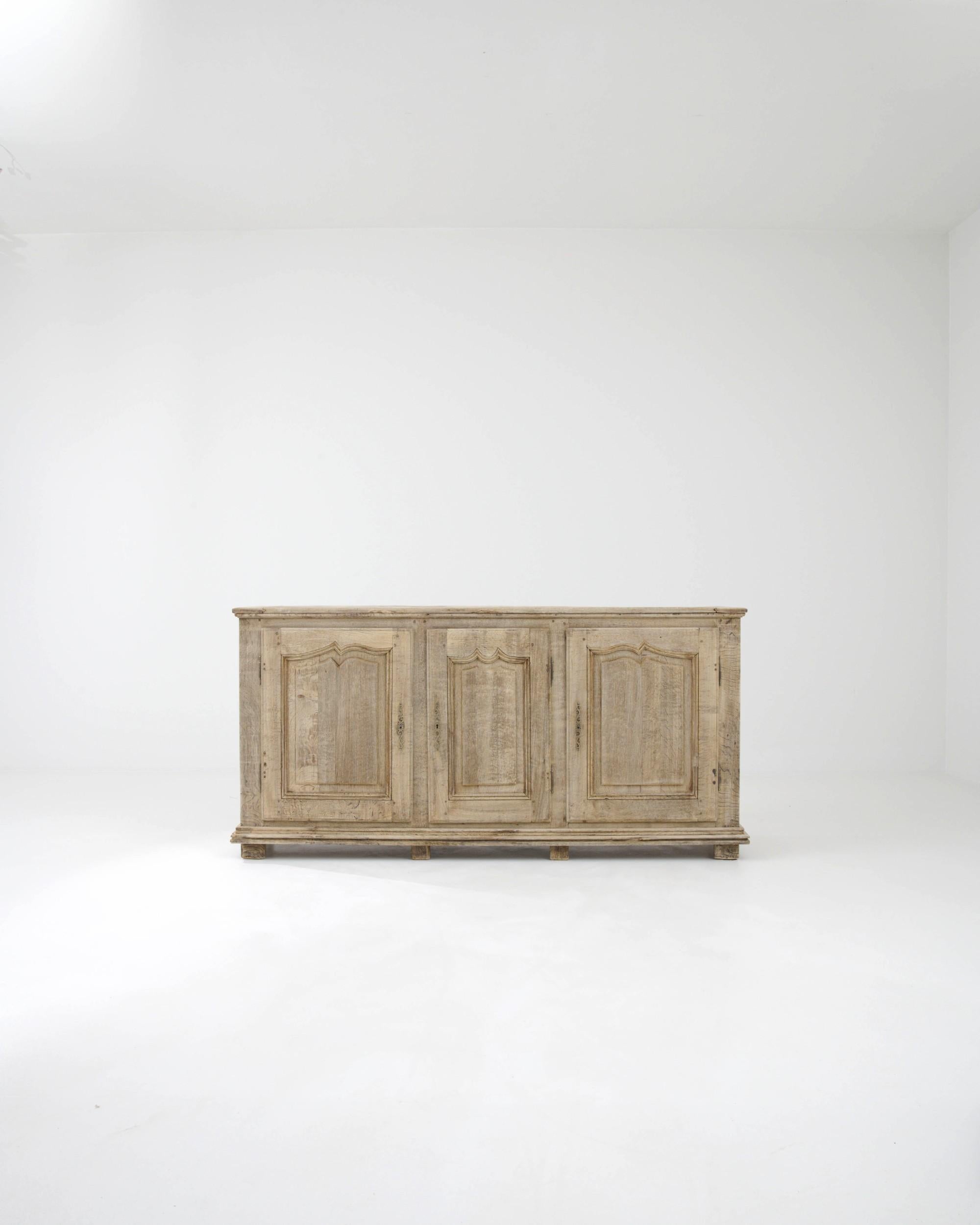 The elegant simplicity of this antique oak buffet gives it a timeless appeal. Made in France in the early 1800s, the cabinet is broad, spacious and sturdily constructed – built with the intention of serving the needs of a Provincial household for