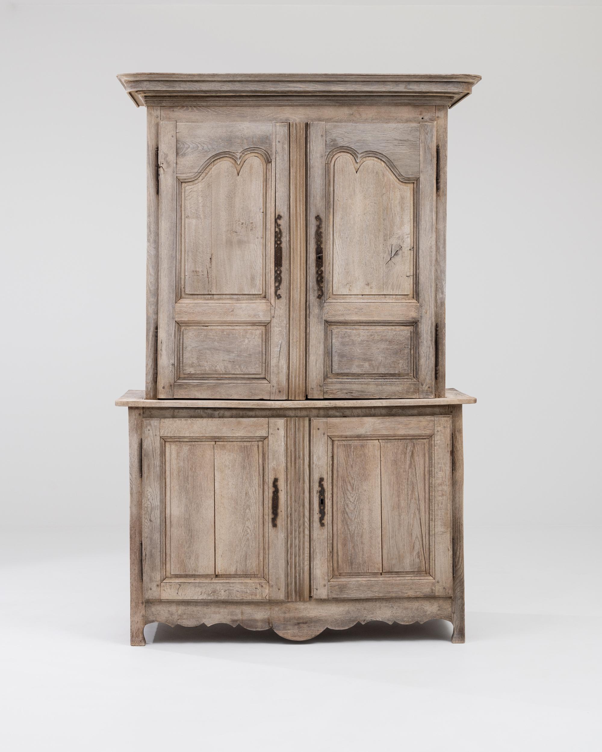 Despite the passing of the centuries, this antique Provincial cabinet in natural oak has retained every ounce of its vivacious charm. Made in France in the early 1800s, the swooping lines of the panels on the upper doors bring a touch of Rococo