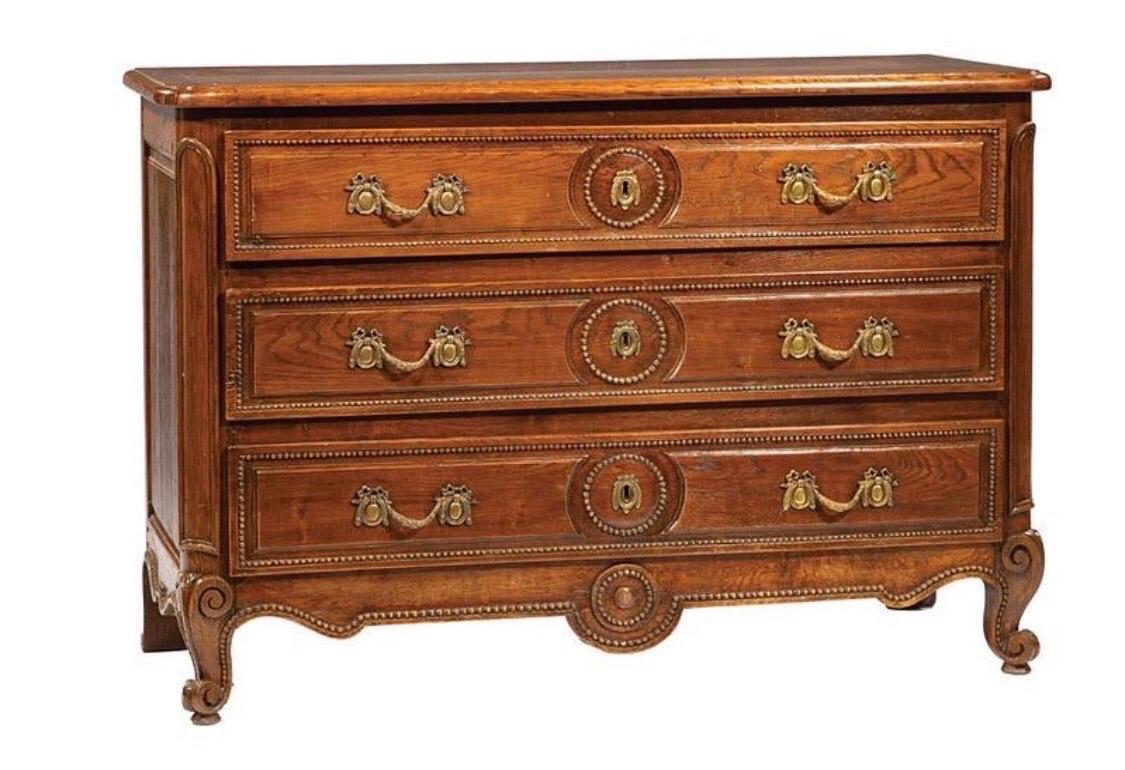 Very handsome early 19th century French Provincial 3-drawer commode made of oak with bead-decorated drawers and apron and scrolled feet.
 