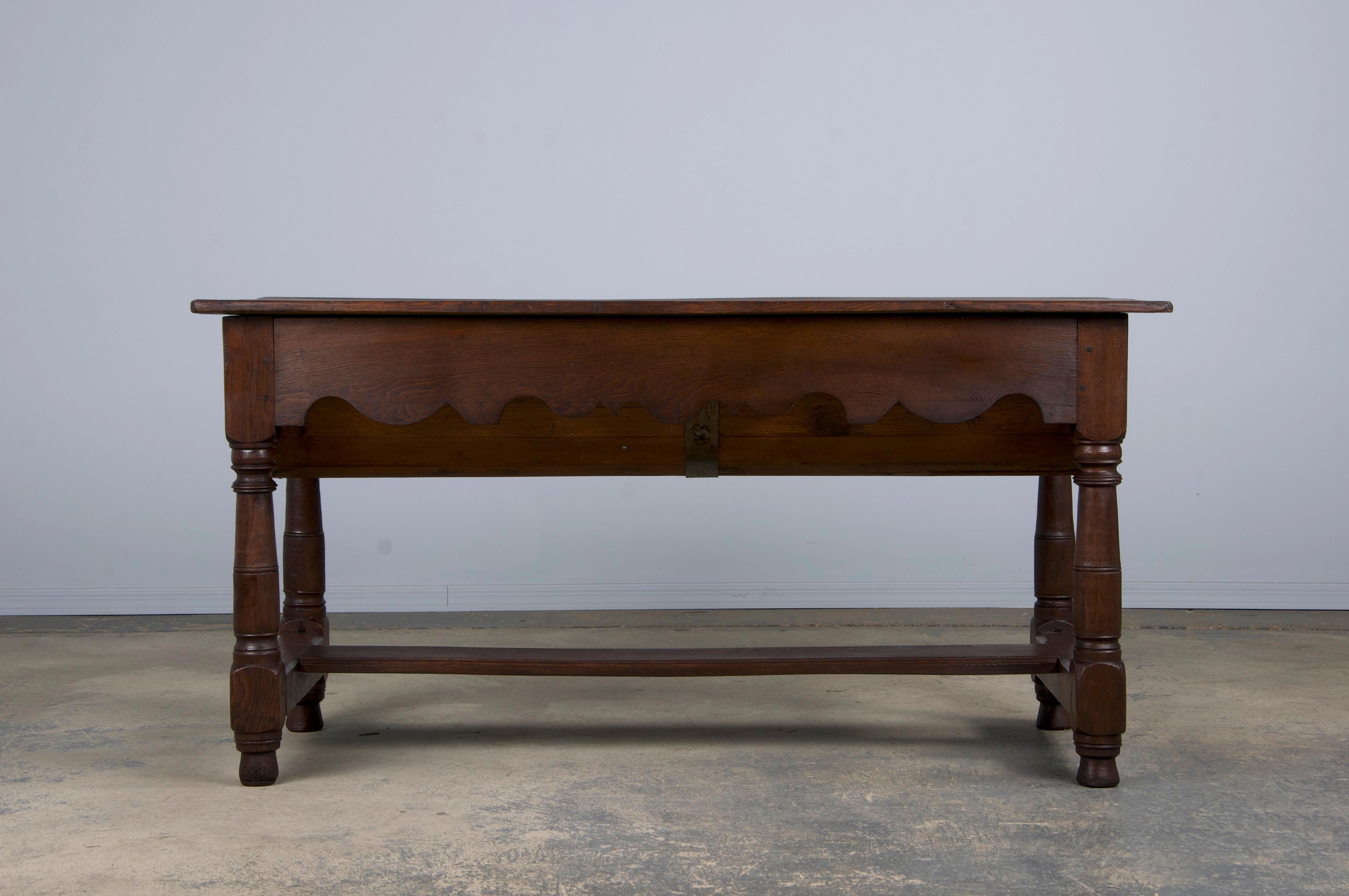 Transport yourself to the rustic charm of an early 19th-century French Provincial farmhouse with this beautiful oak dough baking table or kitchen island. Made in the early 1800s, it reflects traditional craftsmanship with a 4.5-foot rectangular