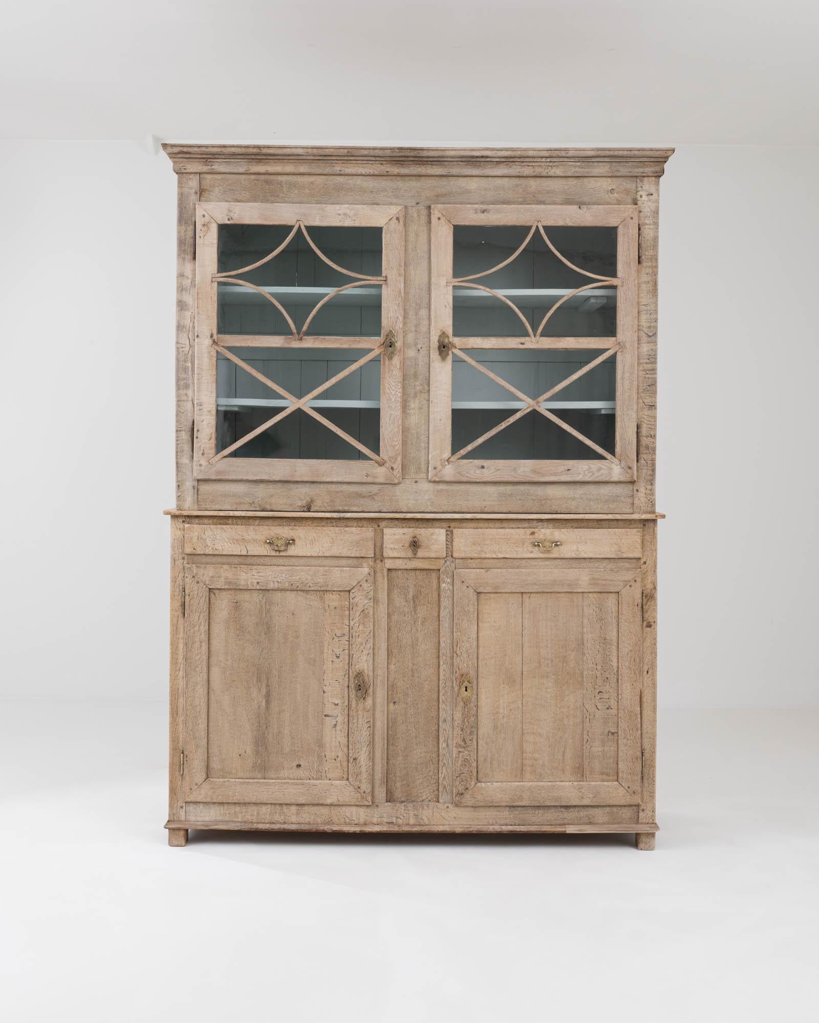 Beautifully crafted to stand the test of time, this antique oak vitrine evokes the Provincial romance of the French countryside. Built in France in the early 1800s, the simple silhouette is enlivened by the geometric mullions which decorate the