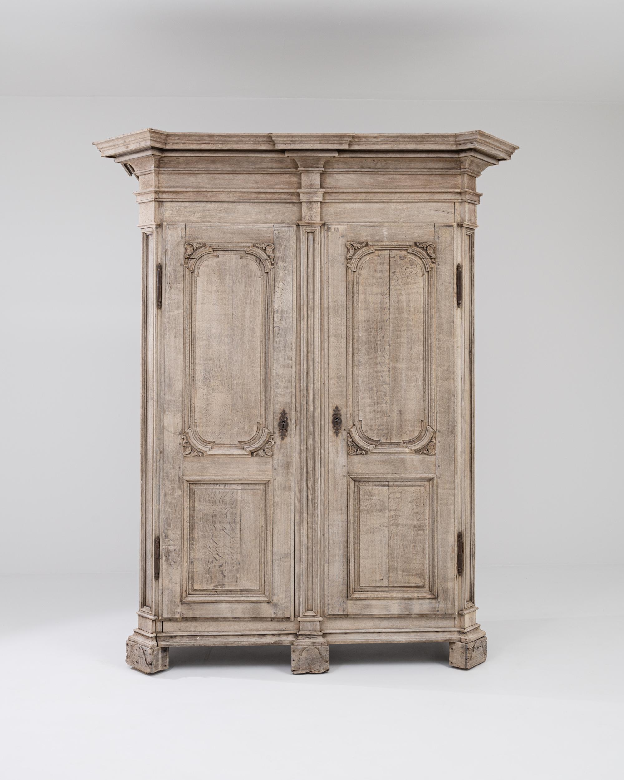 Elegant, auffallend und wunderschön gearbeitet ist dieser antike Eichenschrank, der Sie in seinen Bann ziehen wird. Das im Frankreich des frühen 19. Jahrhunderts hergestellte Design kombiniert eine dramatische Silhouette mit zarten geschnitzten
