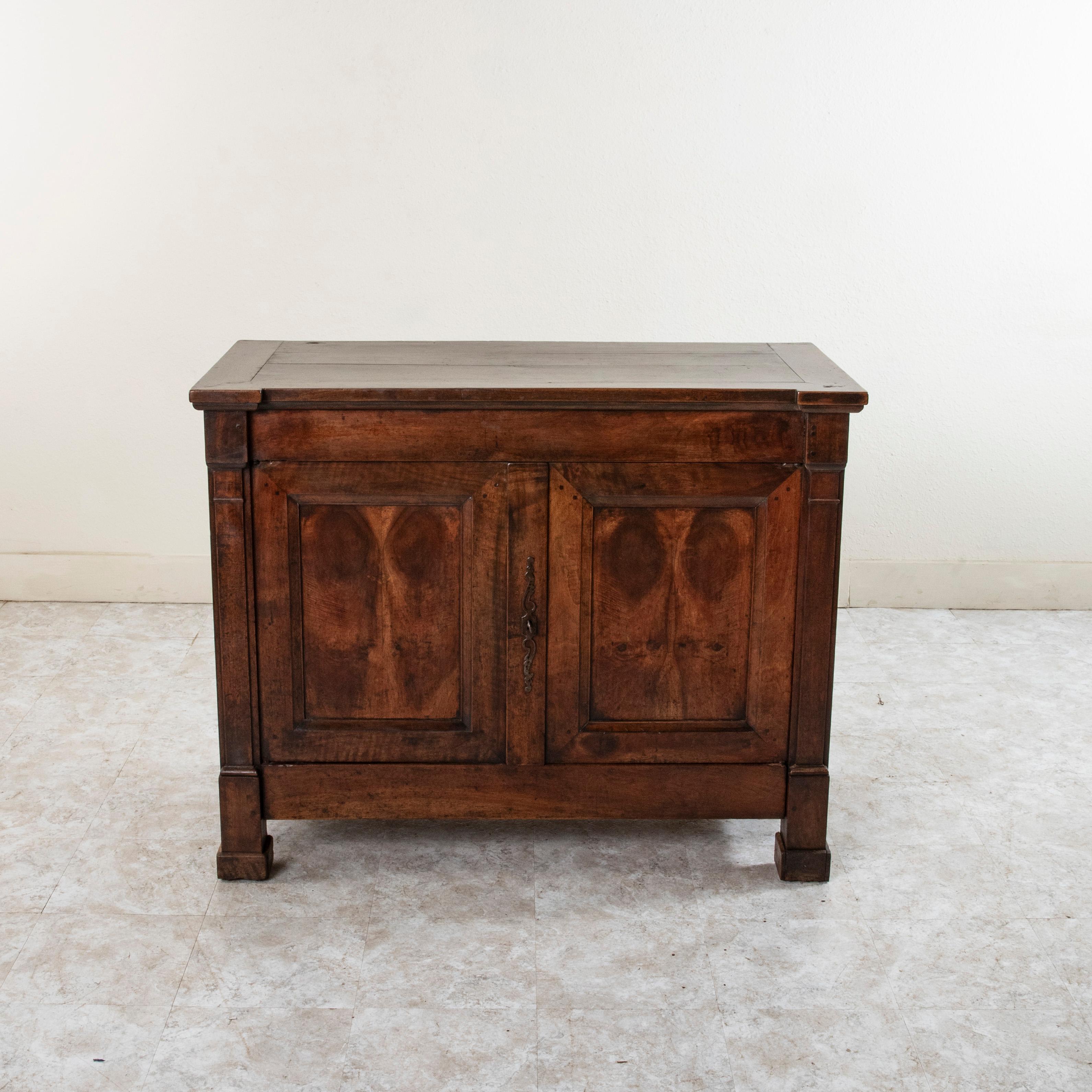 This early nineteenth century French Restauration period buffet or sideboard originally belonged to a judge in a manor house on the Rue de Carcassonne in the city of Tours. This piece features a hinged lift up top that reveals a cavity where flour