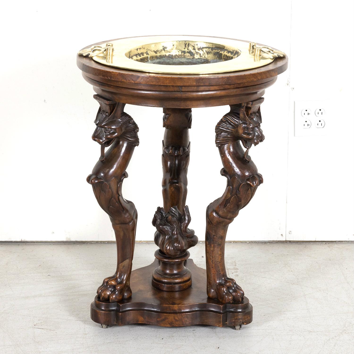 A very fine early 19th century French Restauration period tripod brazier or hand warmer handcrafted of walnut by skilled artisans in Lyon, circa 1820s. This elegant round table features a circular top having the original removable twin handled brass