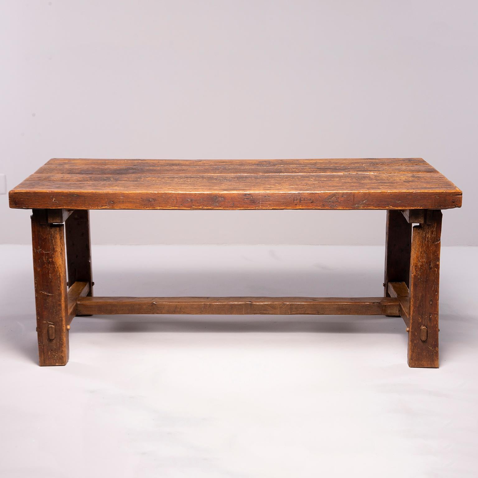 Sturdy rustic oak table found in France, circa 1830s. Top consists of four oak planks, stretchers are joined with mortice and tenon joints. Significant visible wear and patina, structurally solid.