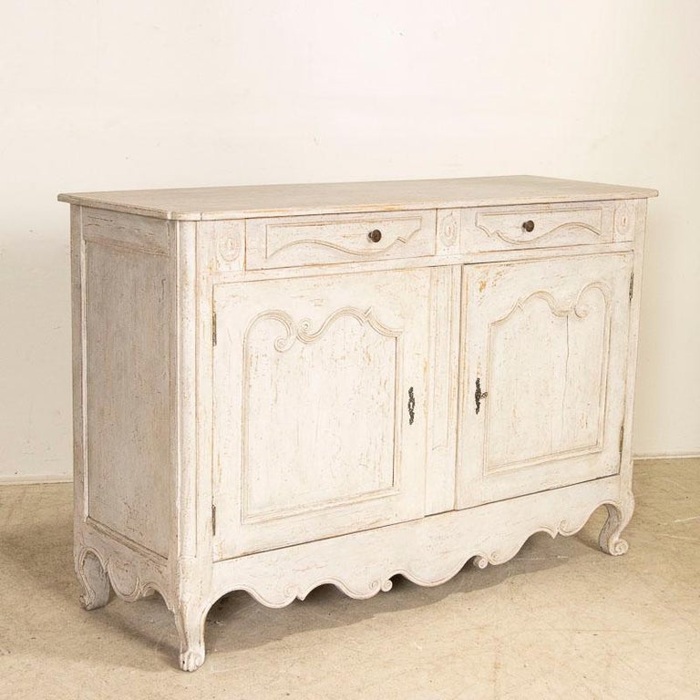 This delightful sideboard has been given a white painted finish, adding to its charming French country style. The paint has been gently distressed revealing the natual wood below, softening the look and adding an aged grace to the finish. Take note