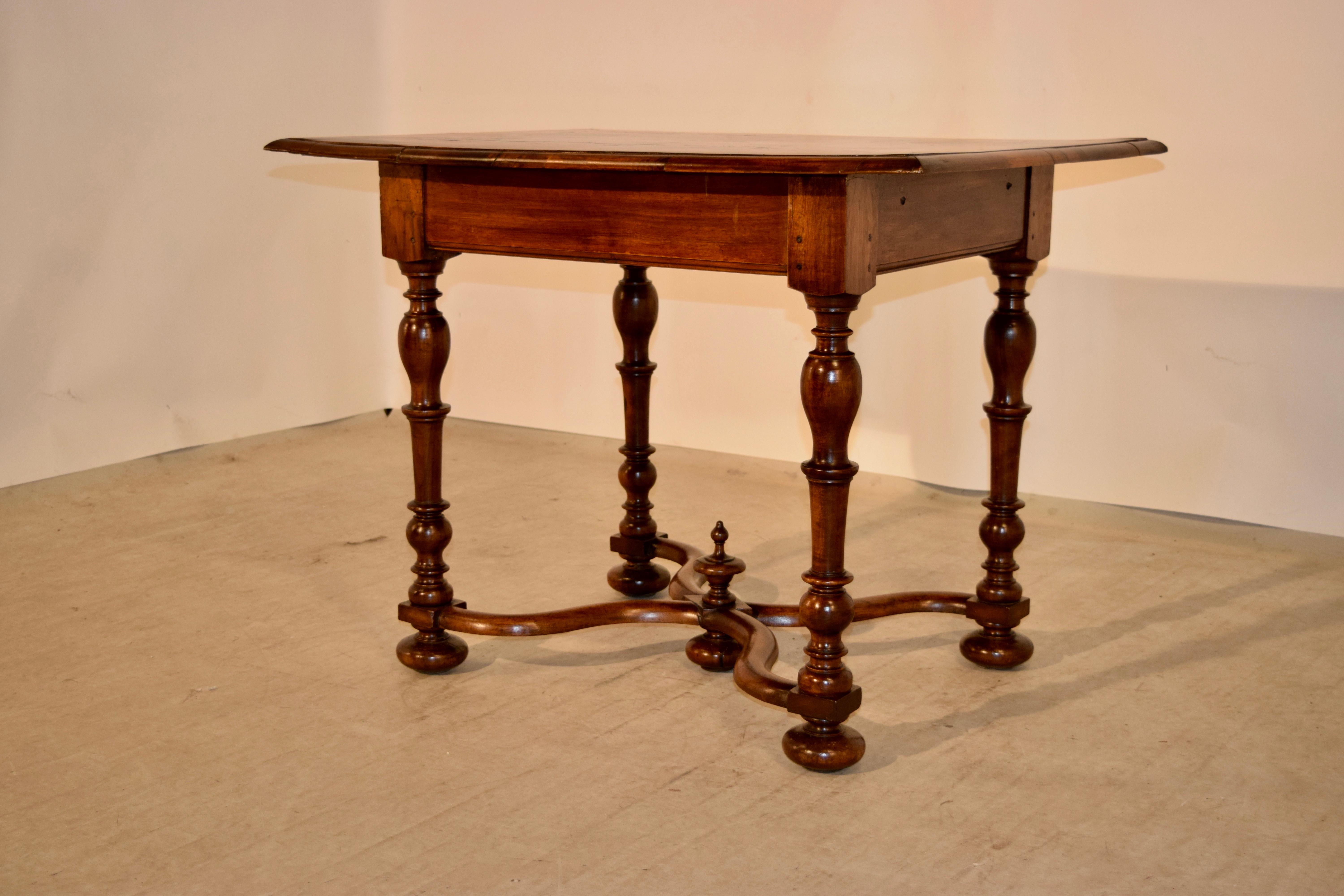 19th century French table made from walnut. The top is beautifully detailed with cross banding around the edges in a lovely pattern surrounding a central pattern with burl in a matching design. The top is finished with a beveled edge and follows