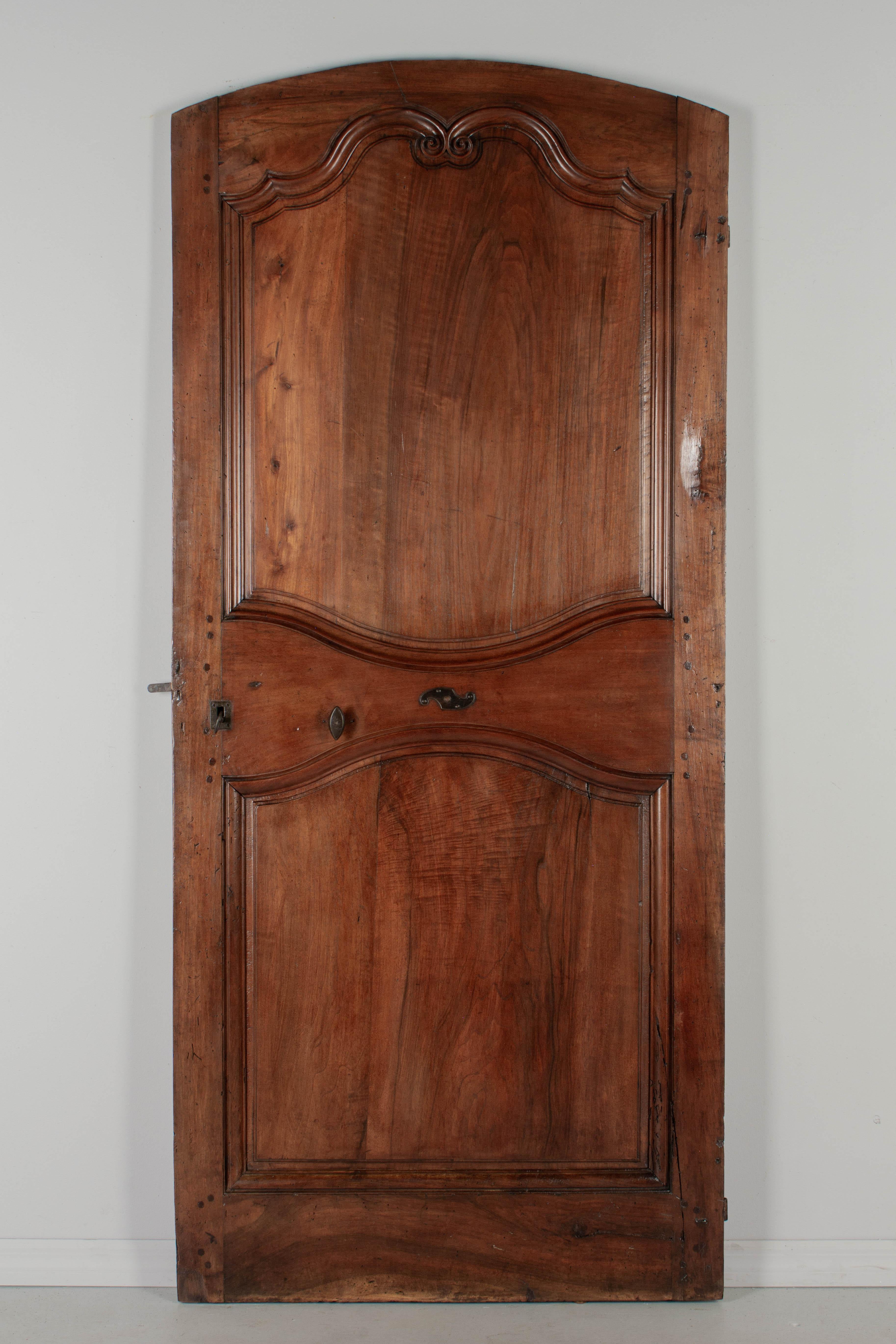 Porta in noce in stile Luigi XV del XIX secolo proveniente dalla Valle della Loira. Questa porta interna a due lati è realizzata con spesse tavole di noce massiccio con decorazioni a volute intagliate a mano tipiche della regione. Grandi cerniere in