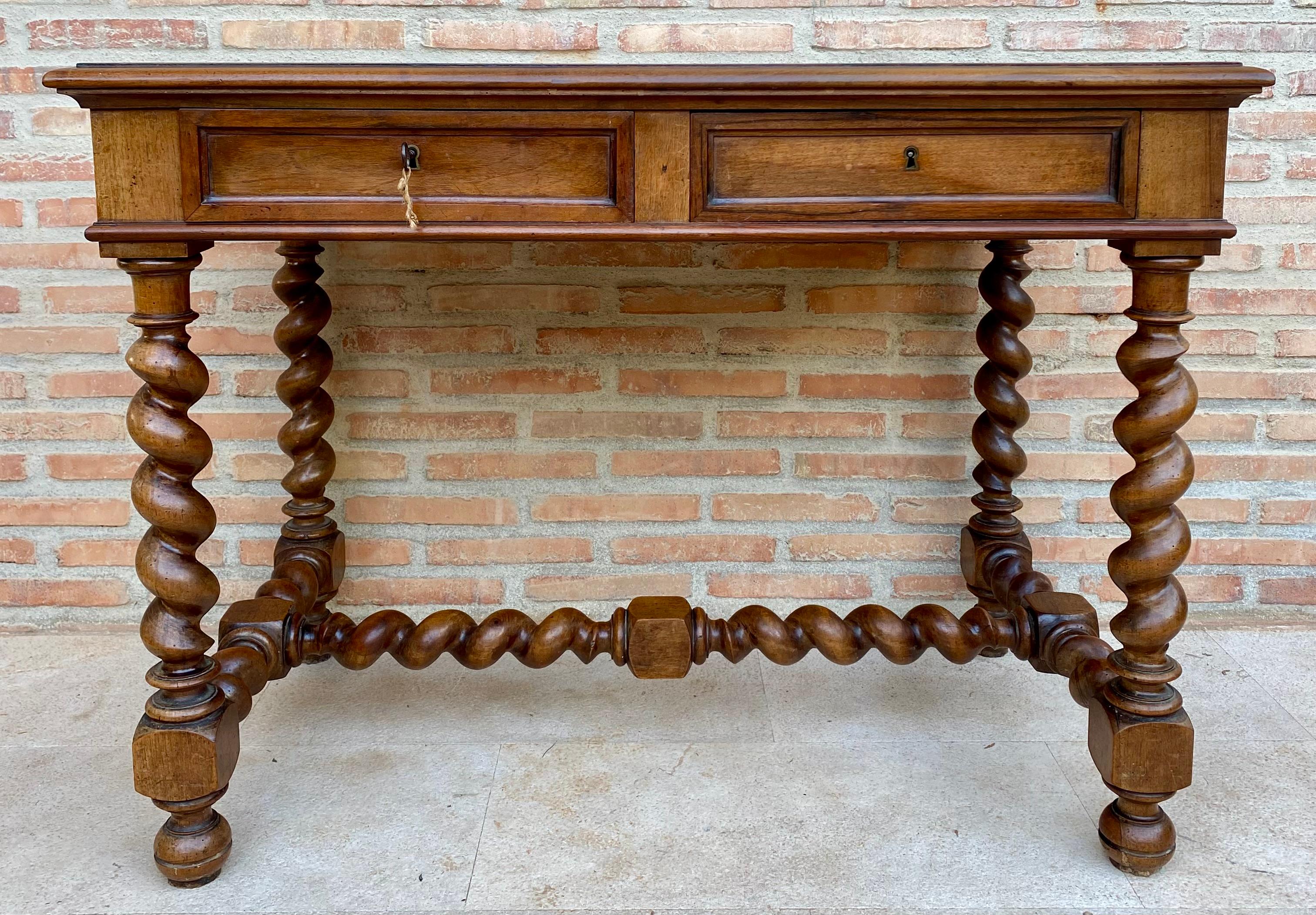 Belle pièce de bibliothèque en noyer pouvant servir de bureau ou de table de travail. Fabriqué en bois de noyer robuste. Tous ses pieds et traverses sont solomoniques et il possède deux tiroirs avec sa poignée en bois et une seule clé, il est du
