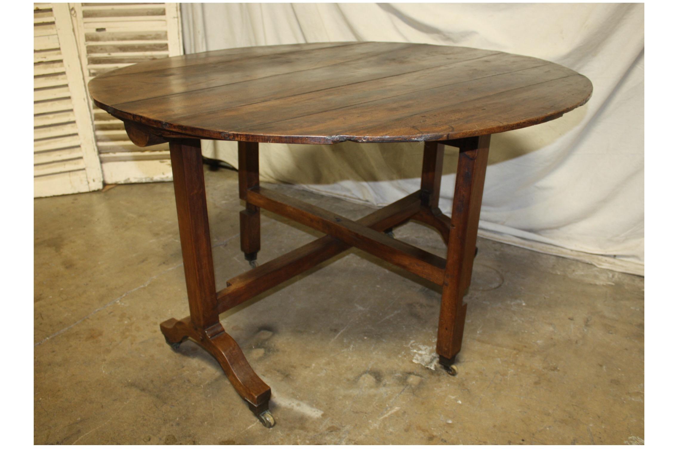 Early 19th century French wine table. The top is a flamed walnut wood and the feet wears its original rolls.
