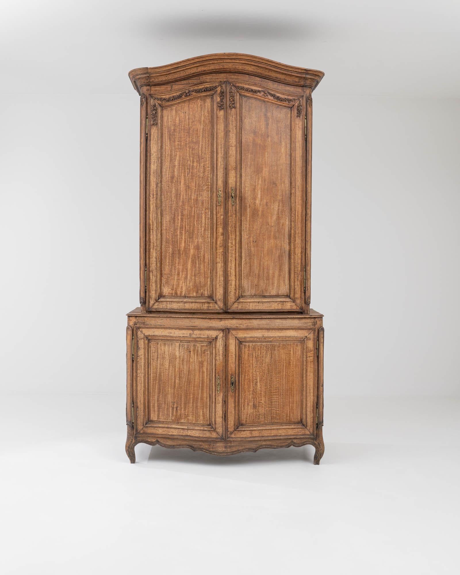 Tall and graceful, this antique wooden cabinet offers an attractive period piece. Hand-built in France in the early 1800s, elegant Rococo details bring out the delicate character of the generously proportioned case. Cabriole feet create a poised