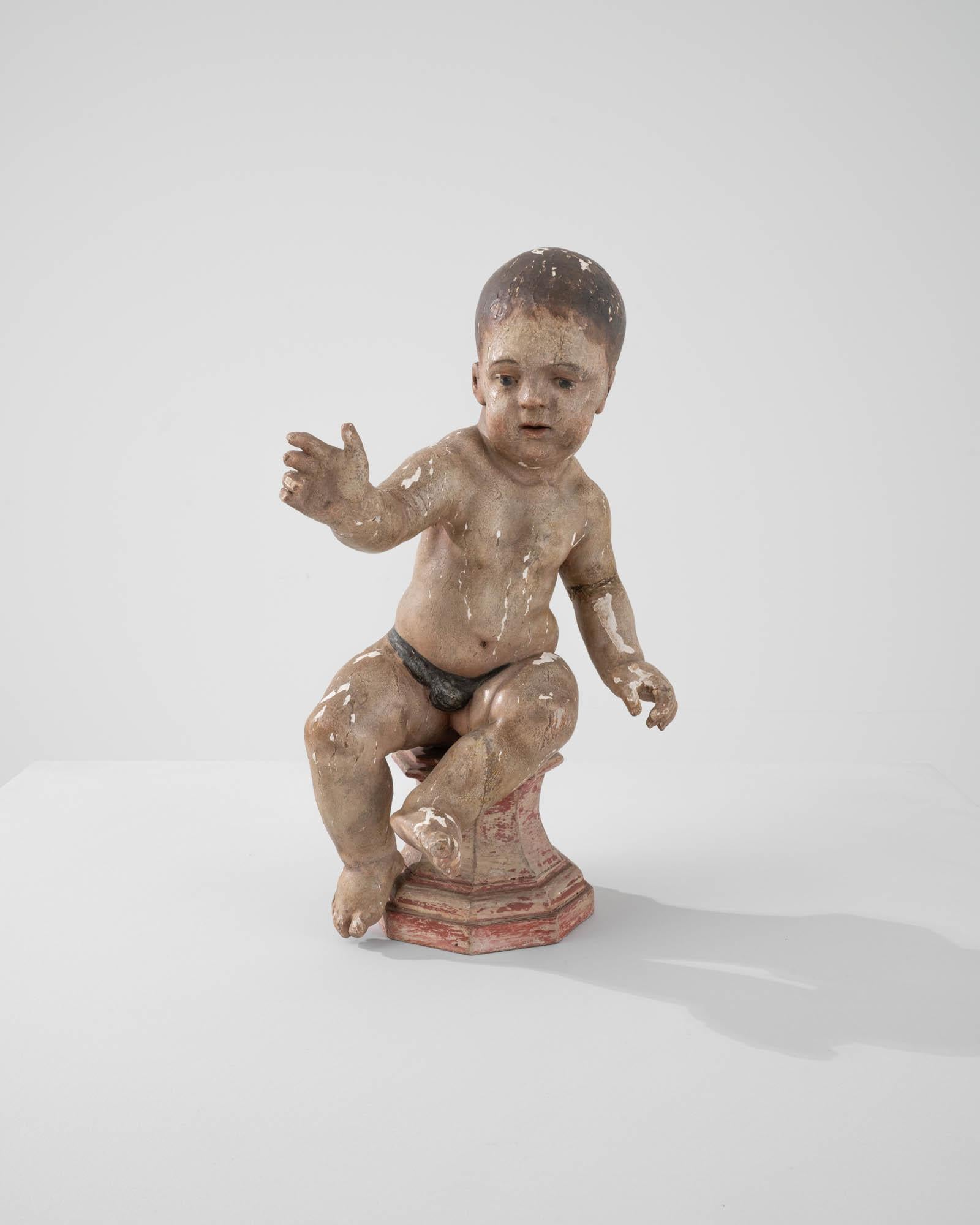 Les traits doux et les détails tendres de cette sculpture ancienne en bois représentant un jeune enfant restent frais malgré les marques du temps. Fabriquée en France au début des années 1800, cette pièce aurait probablement fait partie d'une scène