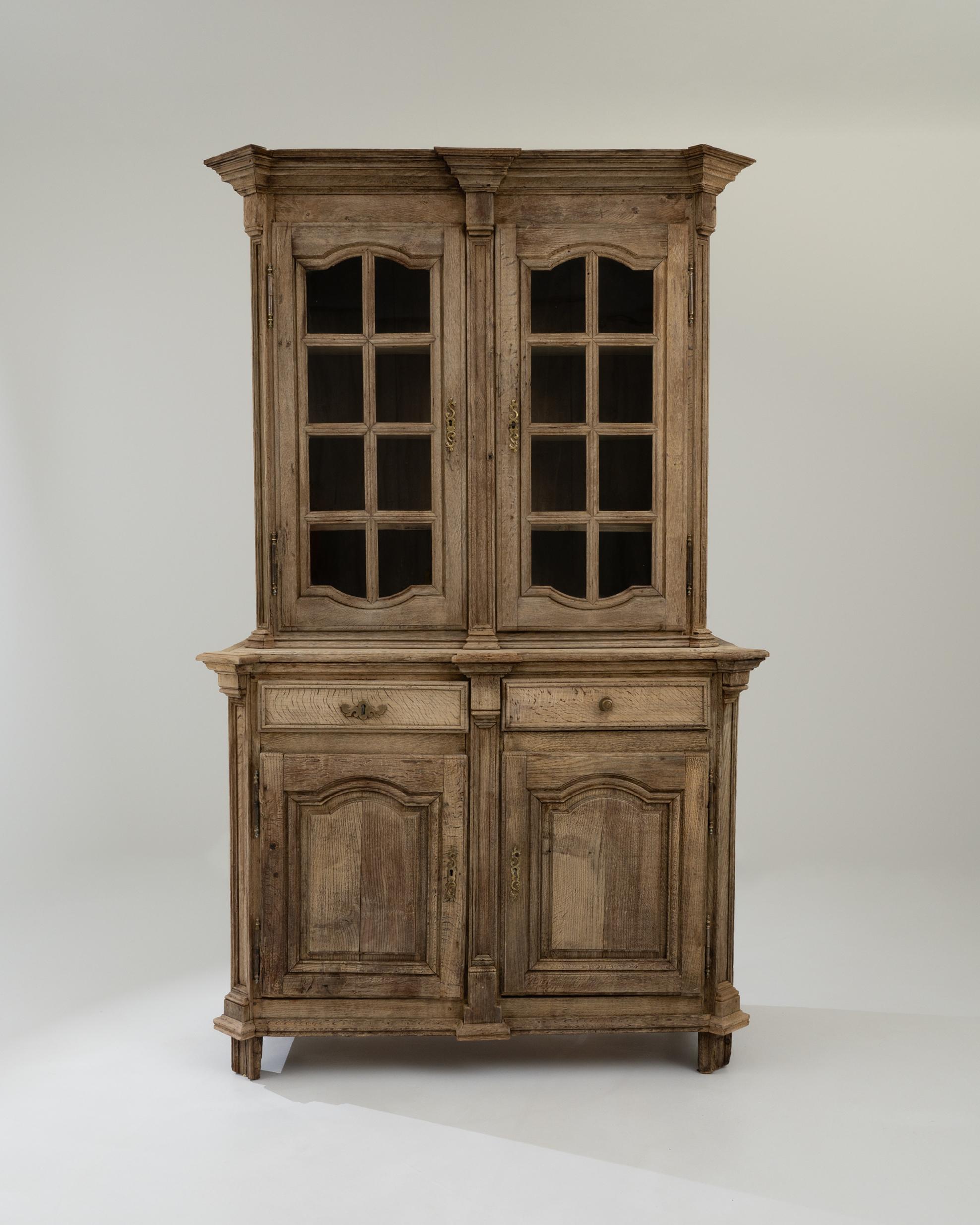 A wooden vitrine created in early 19th century France. Large and grand, yet warm and approachable, this wondrous display cabinet is pulled straight from a fairy tale. A delicate bleaching process has been applied to the surface of the oak, adding an